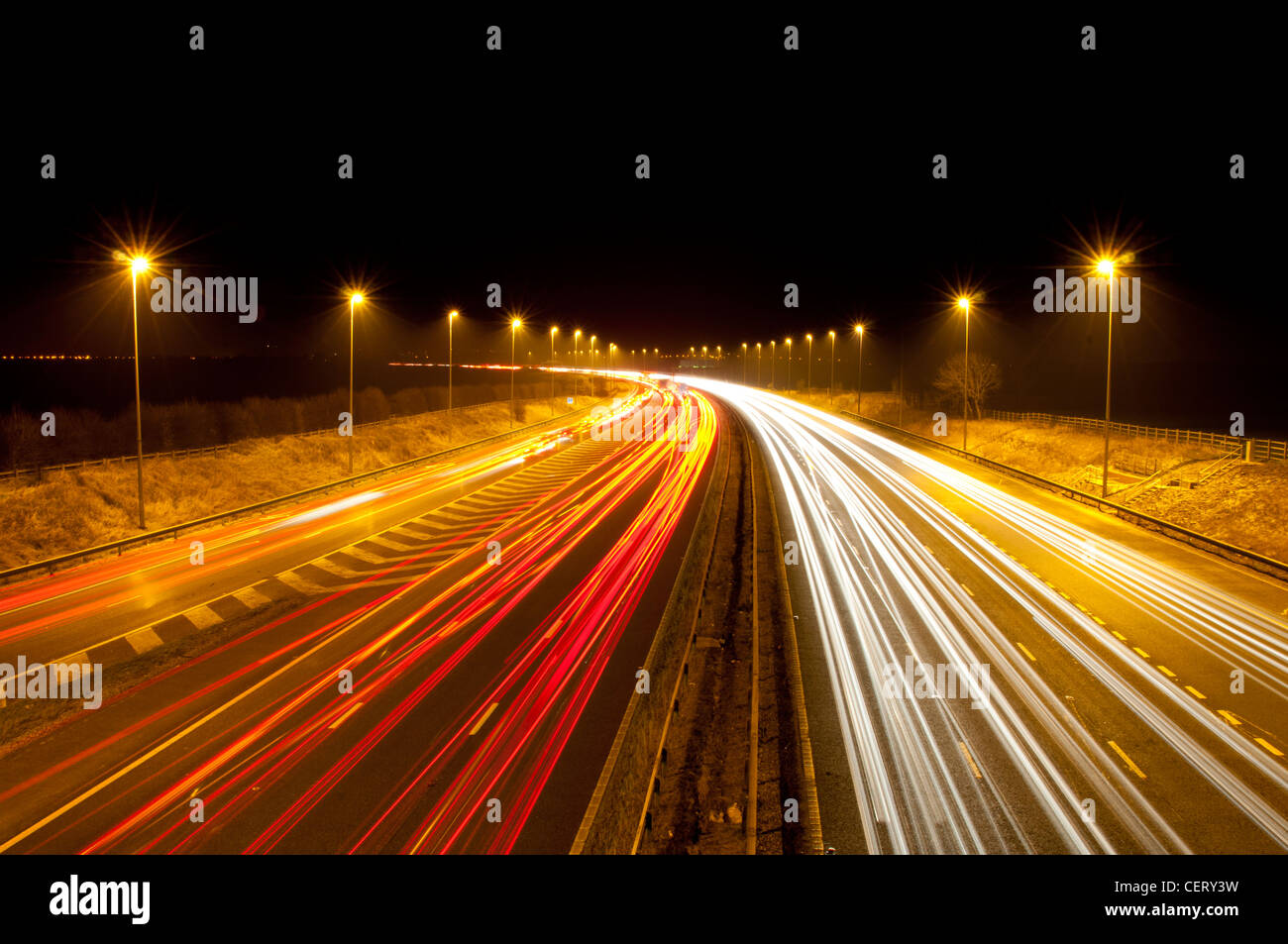 Traffic speeding past on a UK motorway at night in Cheshire Stock Photo