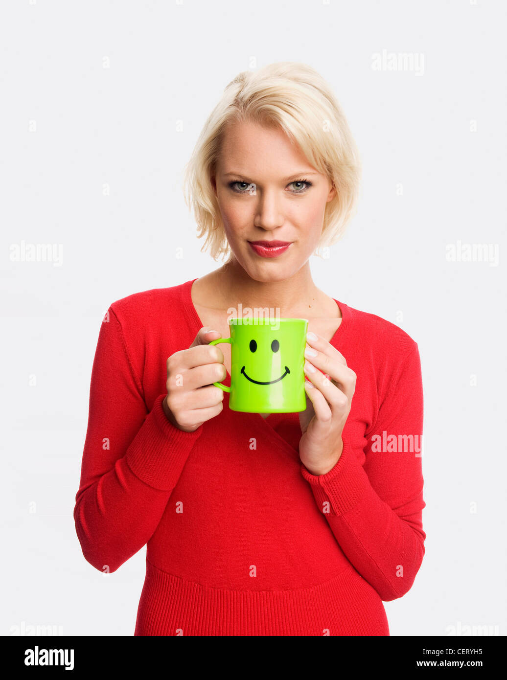 Female holding a green mug with a smiley face Stock Photo