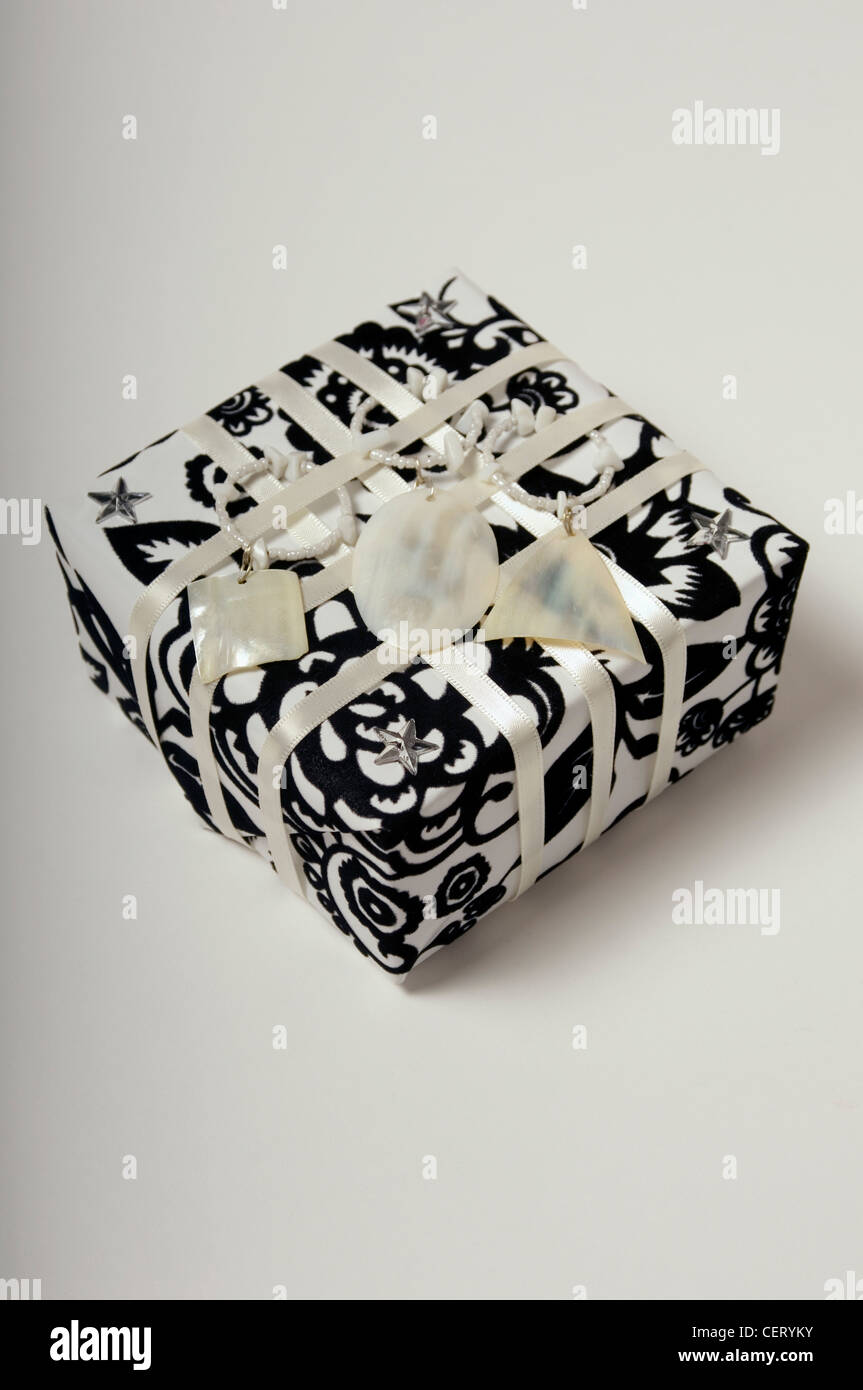 A still life of a present wrapped in black and white flocked wrapping