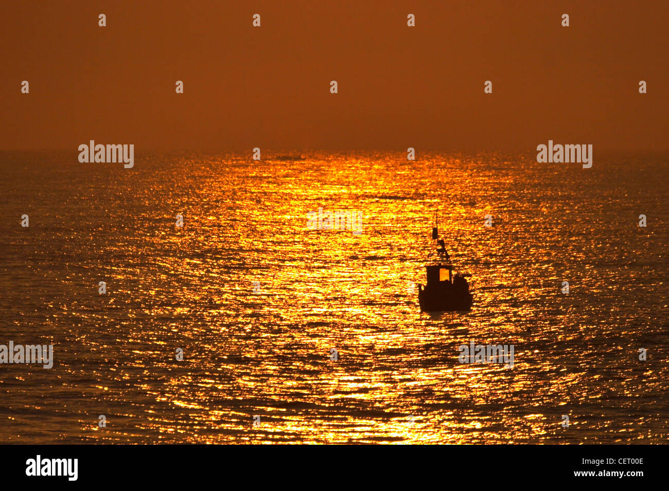 A crab fishing boat heading out to sea at Cromer on the North Norfolk Coast. Stock Photo
