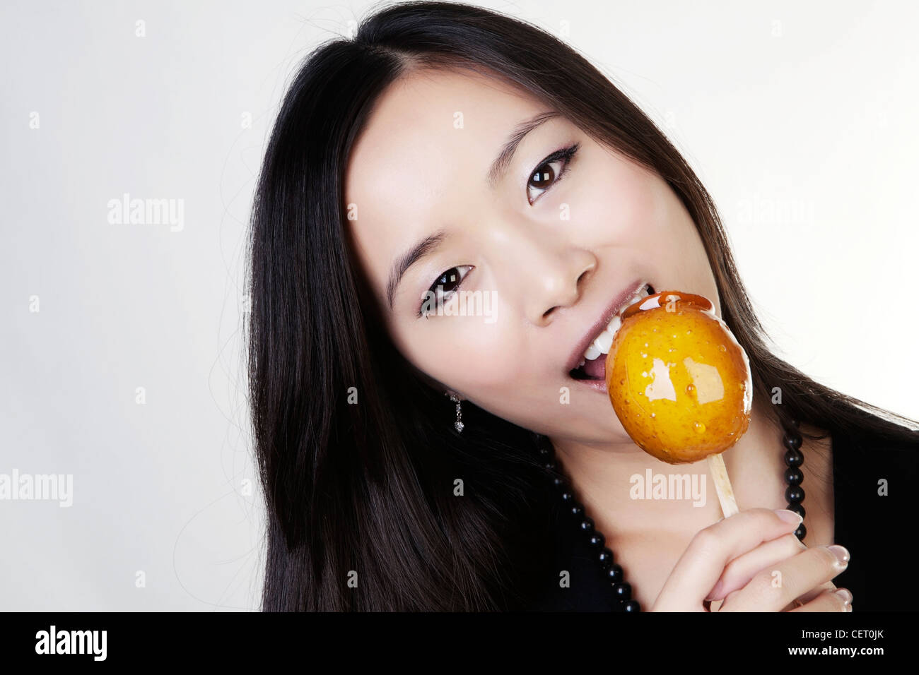 woman looking happy holding a toffee apple she about to eat Stock Photo ...