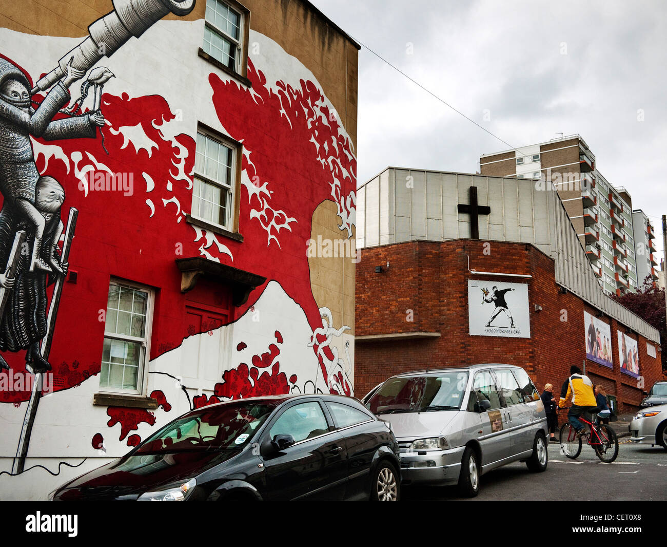 Mural based on the wave by Hokusai on Bristol Wall with a Banksy painting behind on a church Stock Photo