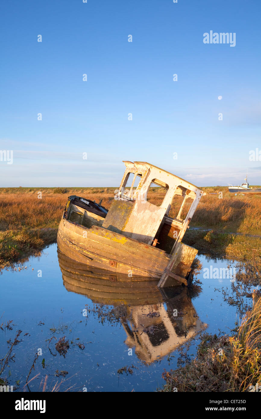 A derelict boat at Thornham Harbour at first light. Stock Photo