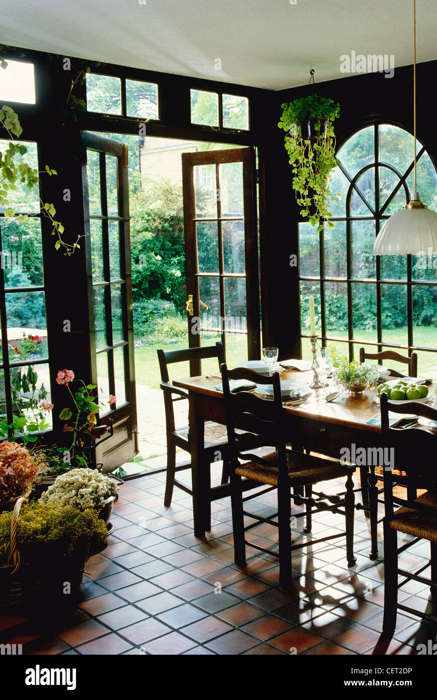 Conservatory with dining table and chairs, looking out into the garden Stock Photo Alamy