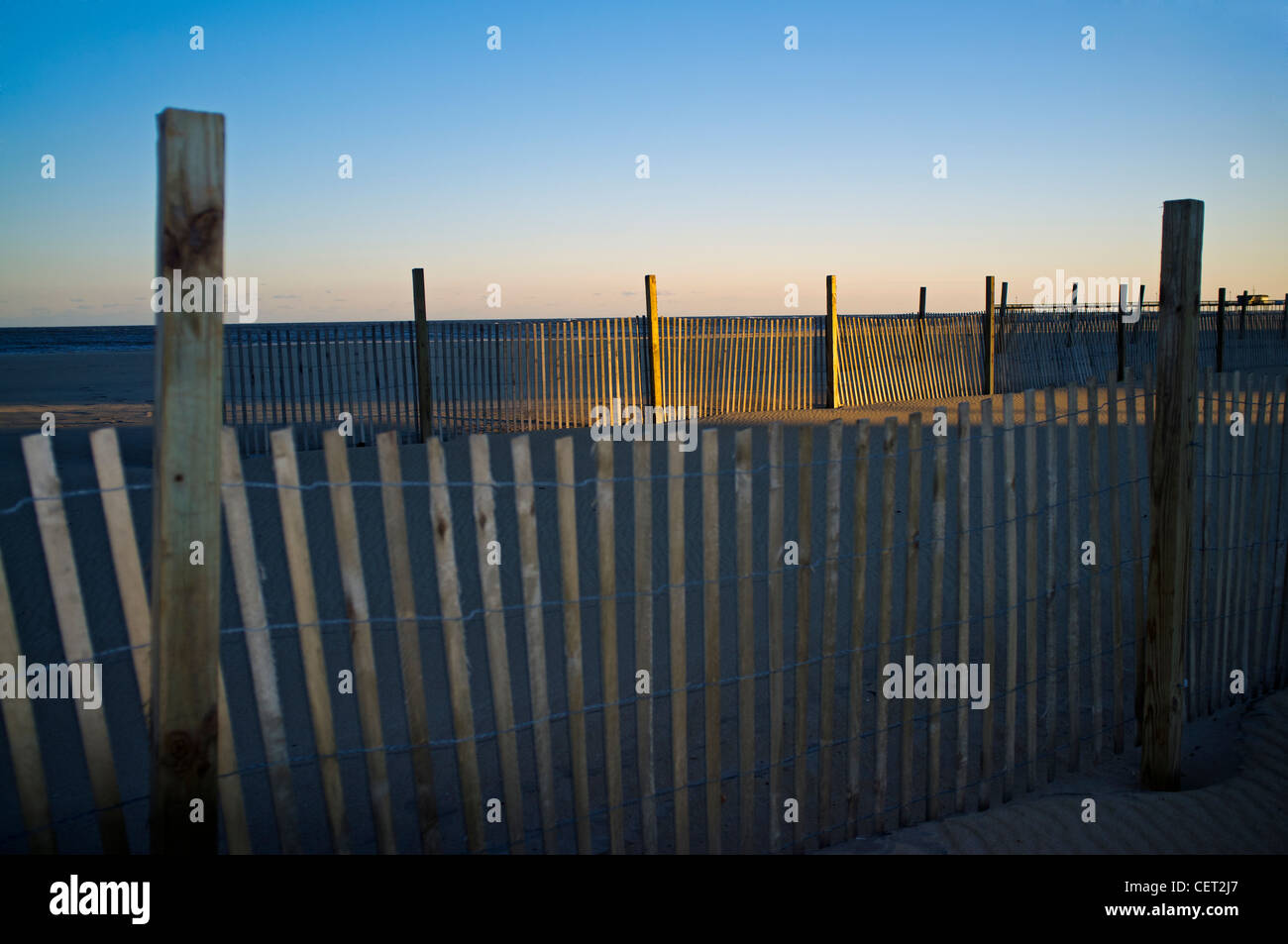 A windbreak fence on the beach at sunset in Ocean City Maryland, USA Stock Photo