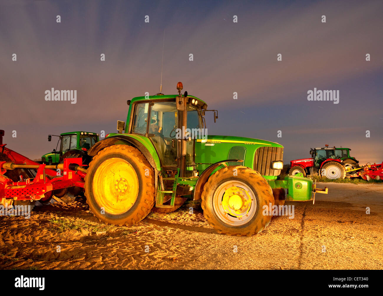 Star trails over tractors in the Norfolk countryside at night. Stock Photo