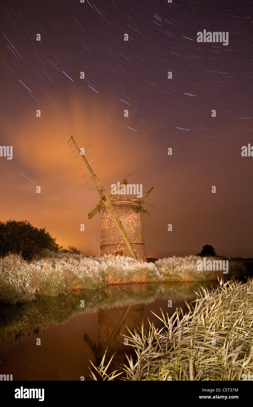 Star trails over the derelict Brograve drainage mill, a grade ll listed building on Brograve level in the Norfolk Broads Nationa Stock Photo