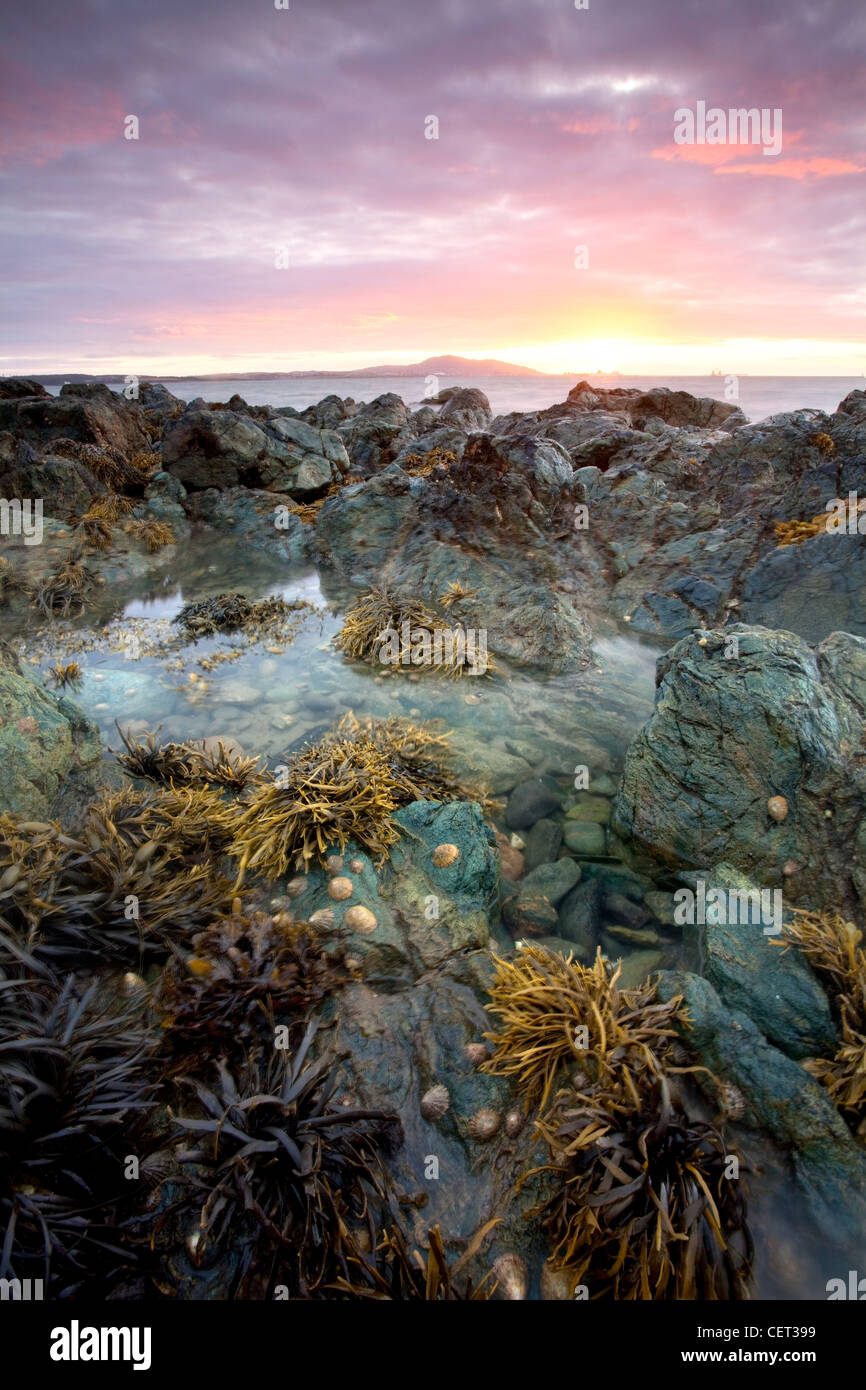 Sunset looking towards Holyhead Mountain viewed from Porth Penrhyn-Mawr on the Isle of Anglesey. Stock Photo