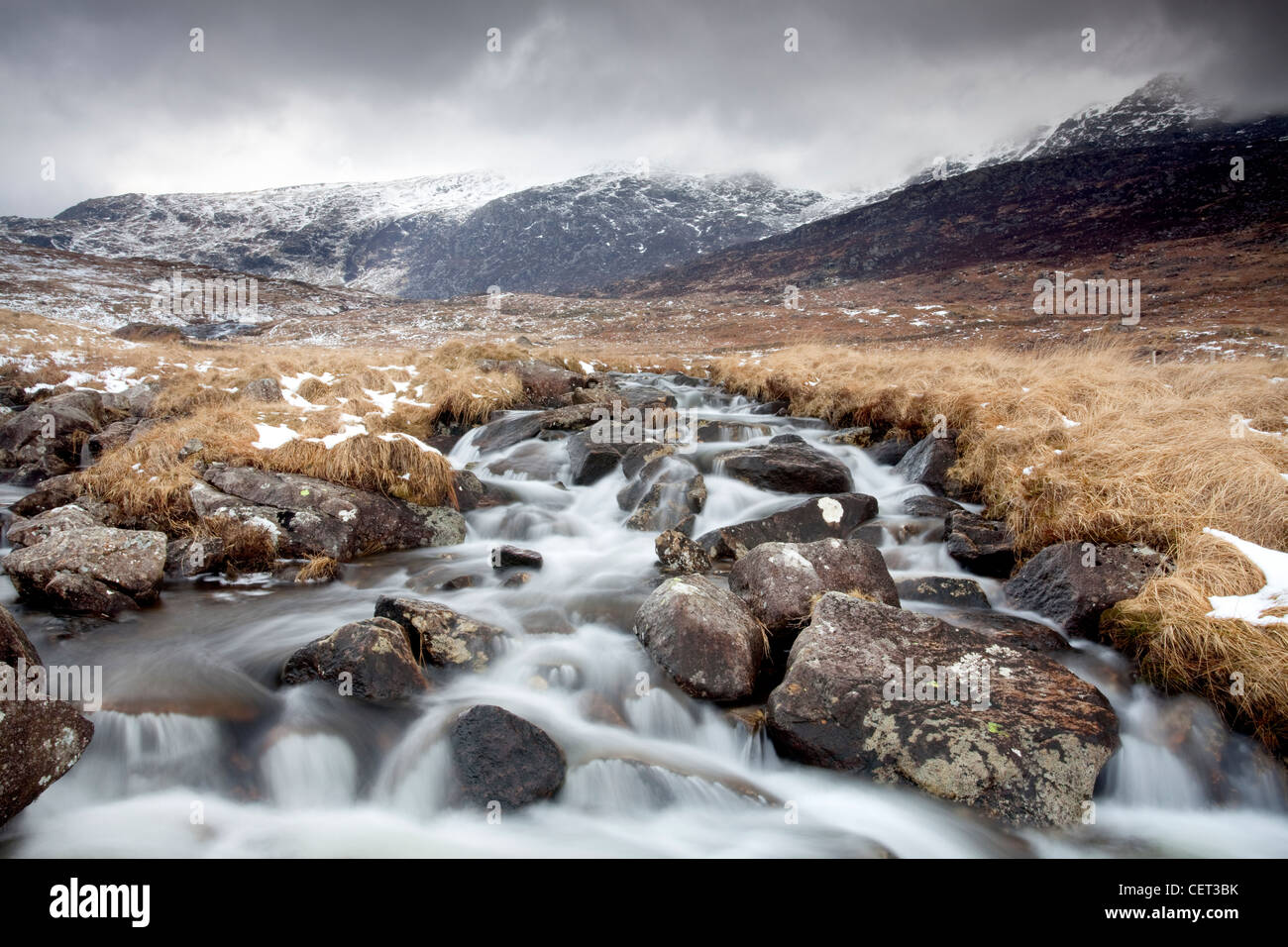 Water flowing down from mountains over rocks in the Snowdonia National Park in Winter. Stock Photo