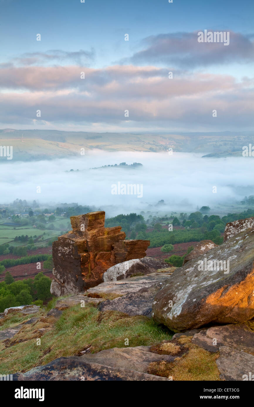 Mist over the village of Calver viewed at first light from Curbar Edge in the Peak District National Park. Stock Photo