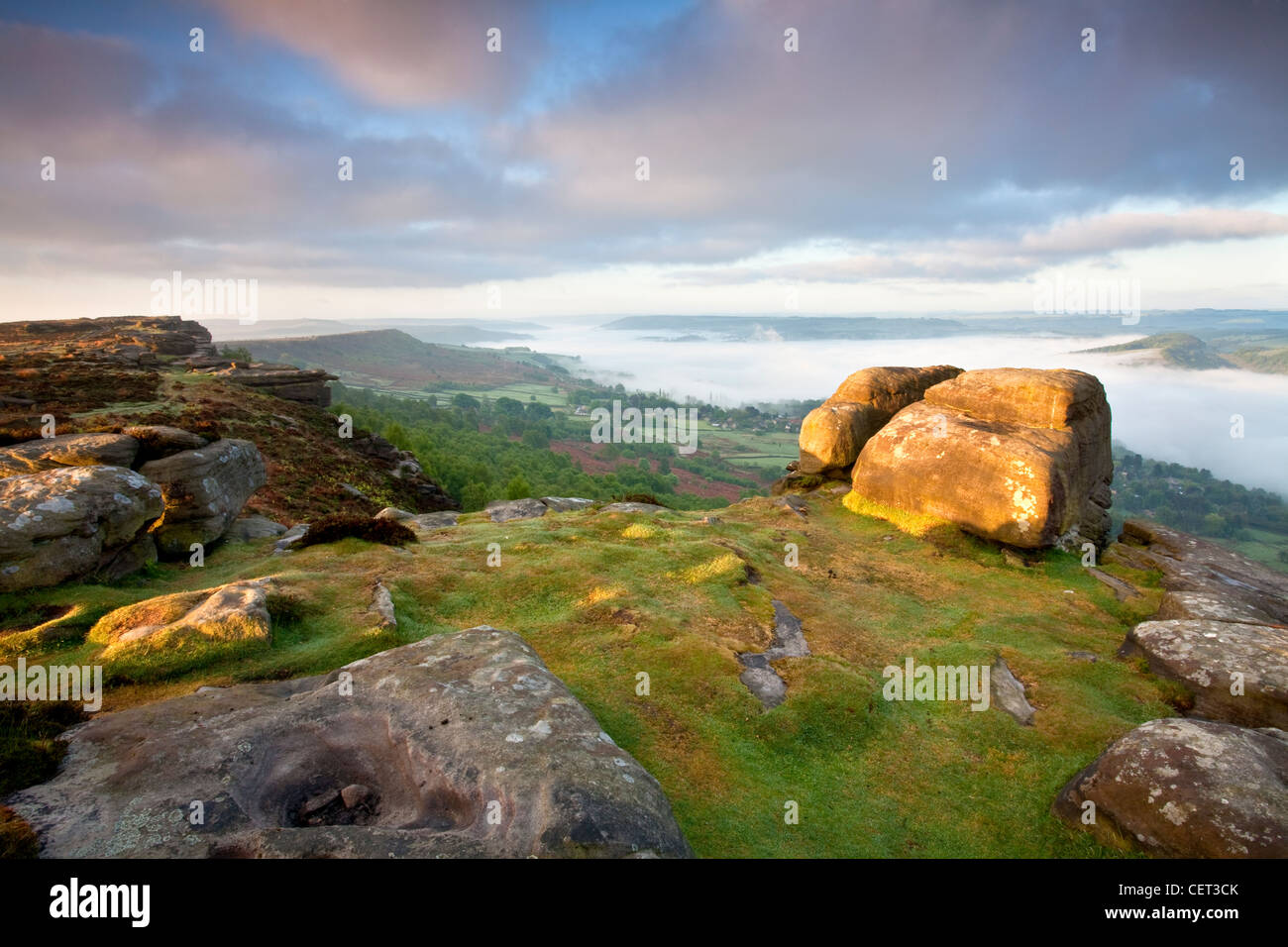 Mist over the village of Calver viewed at first light from Curbar Edge in the Peak District National Park. Stock Photo