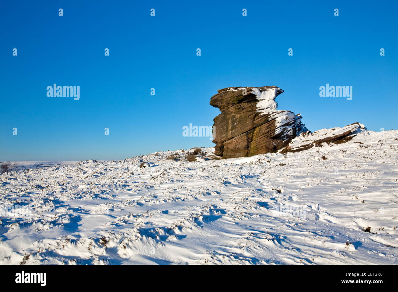 Snow on and surrounding Mother Cap, a large gritstone rock formation in the Peak District National Park. Stock Photo