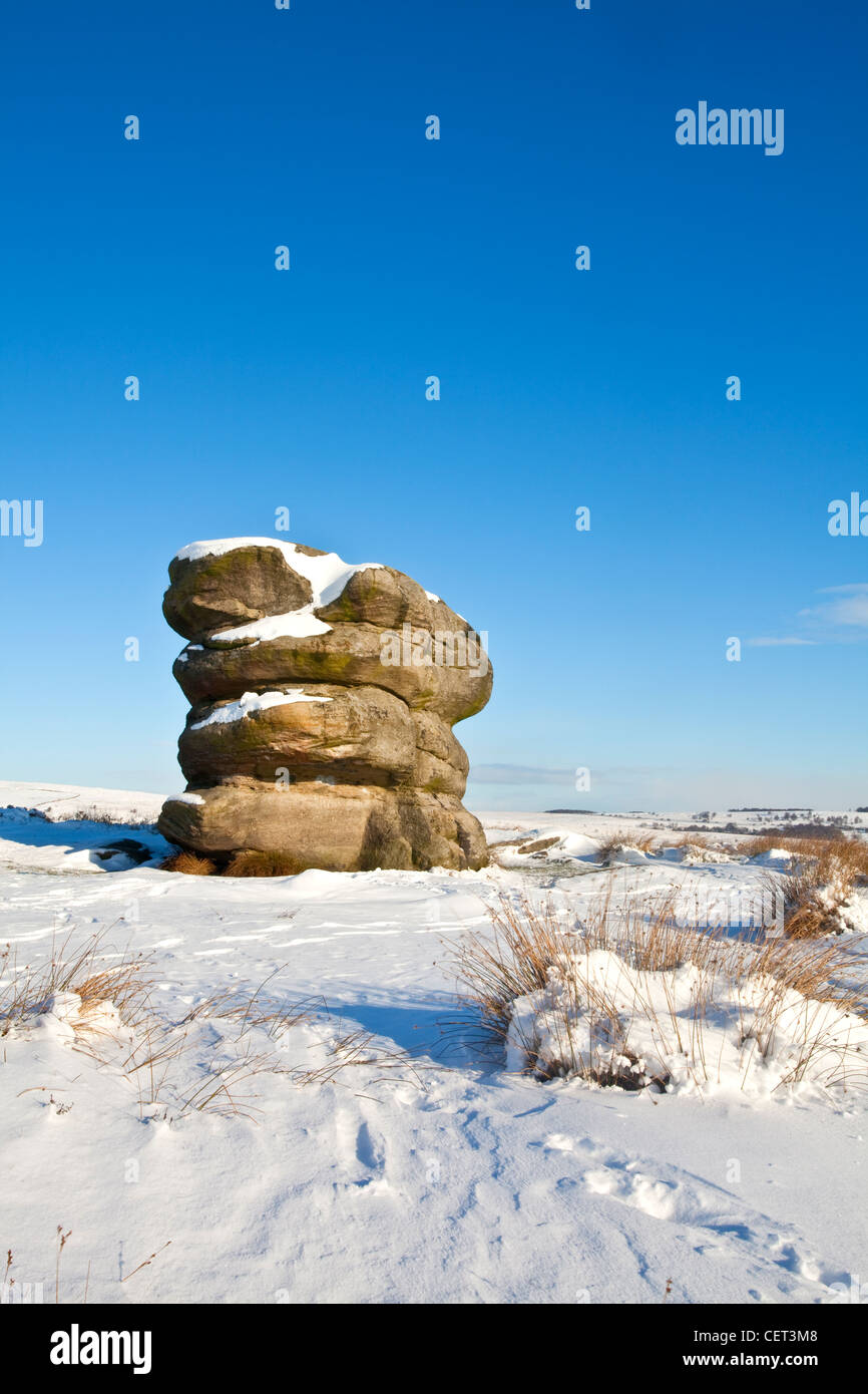 The Eagle Stone on Baslow Edge following a heavy winter snowfall in the Peak District National Park. Stock Photo