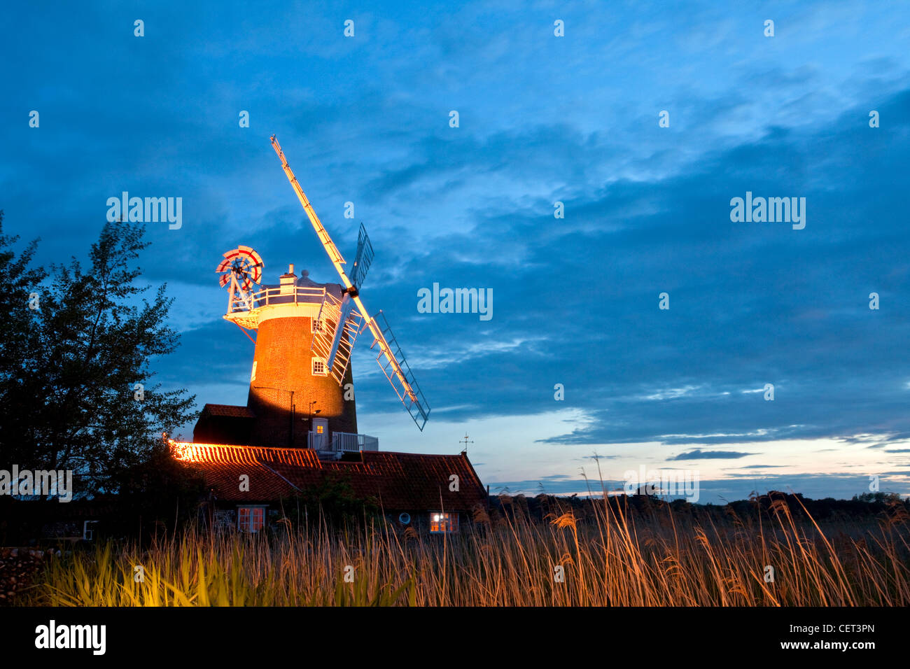 Cley windmill, a grade ll listed tower mill originally built in the early 19th century, illuminated at night. The windmill has b Stock Photo