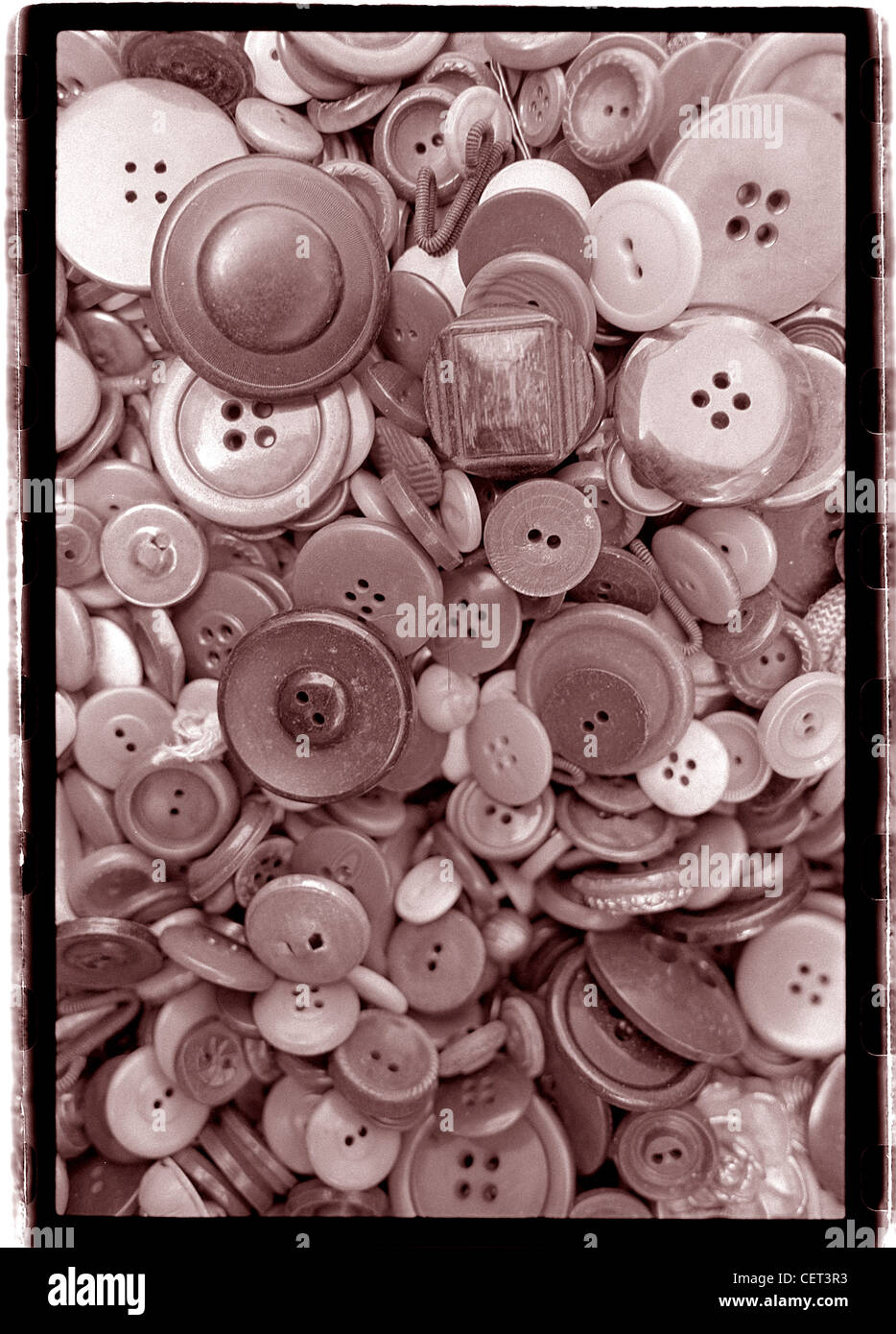 Cheap buttons piled together.  Vertical sepia toned photograph.  Street Fair, collectible junk graphic image patterns busy Stock Photo