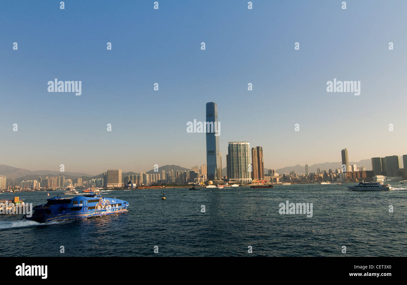 A morning view of Victoria harbor with the ICC tower in the background and a TurboJet boat leaving the Macau Ferry terminal. Stock Photo