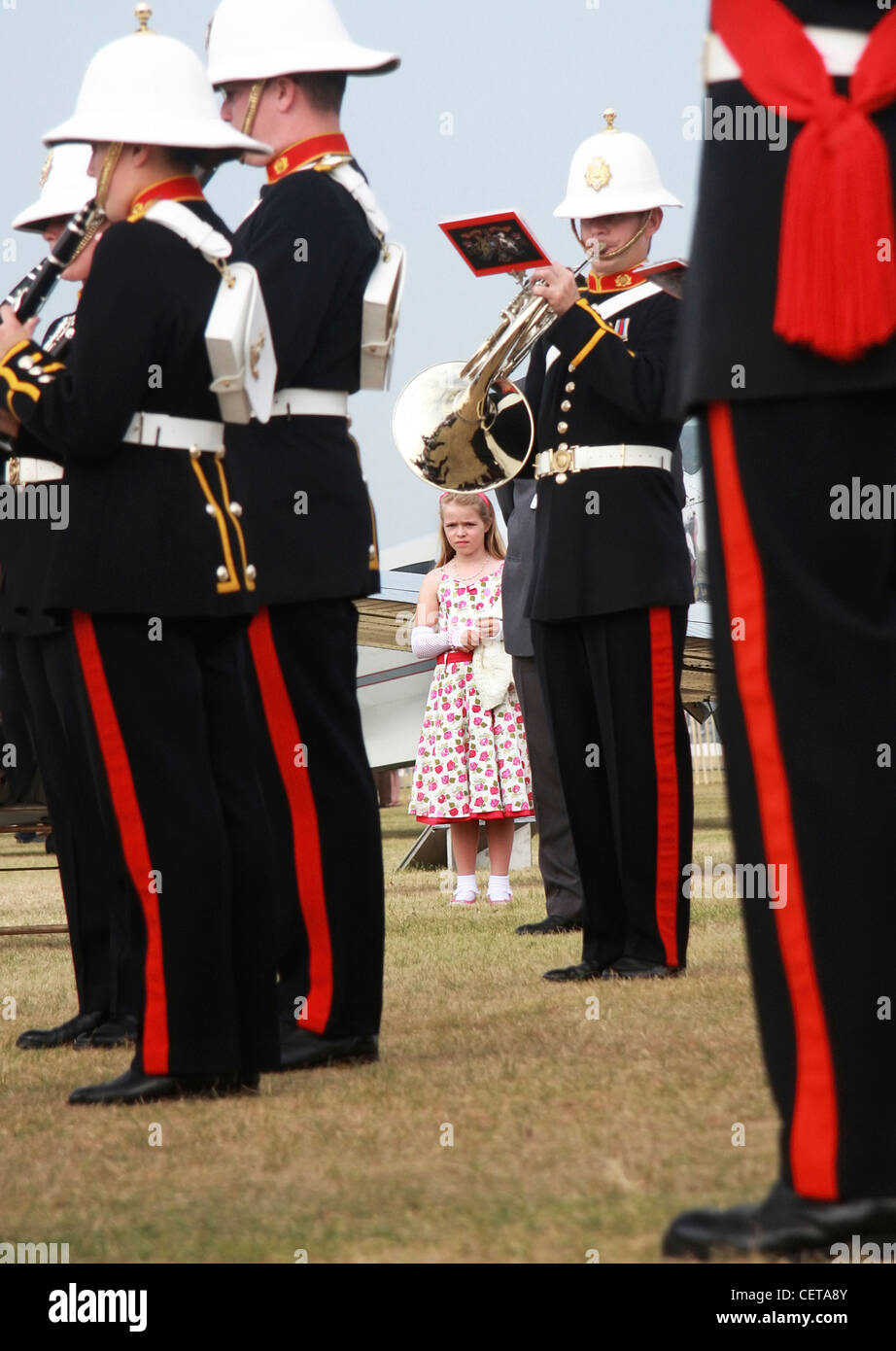 Girl is flower dress listening to Military band at Goodwood Revival. Stock Photo