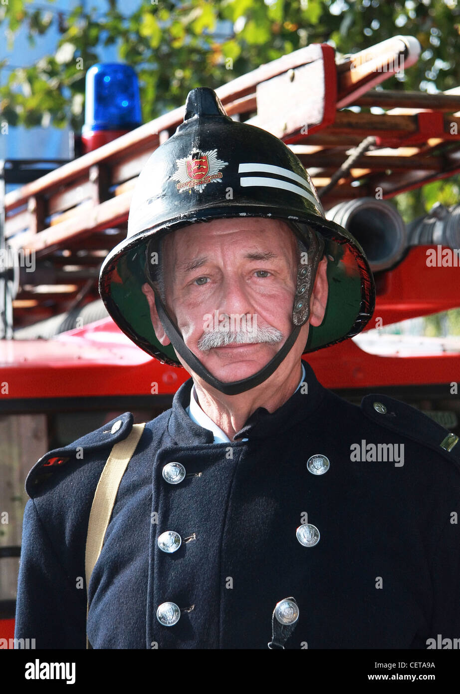 FIreman in retro outfit with ladder truck at Goodwood Revival. Stock Photo