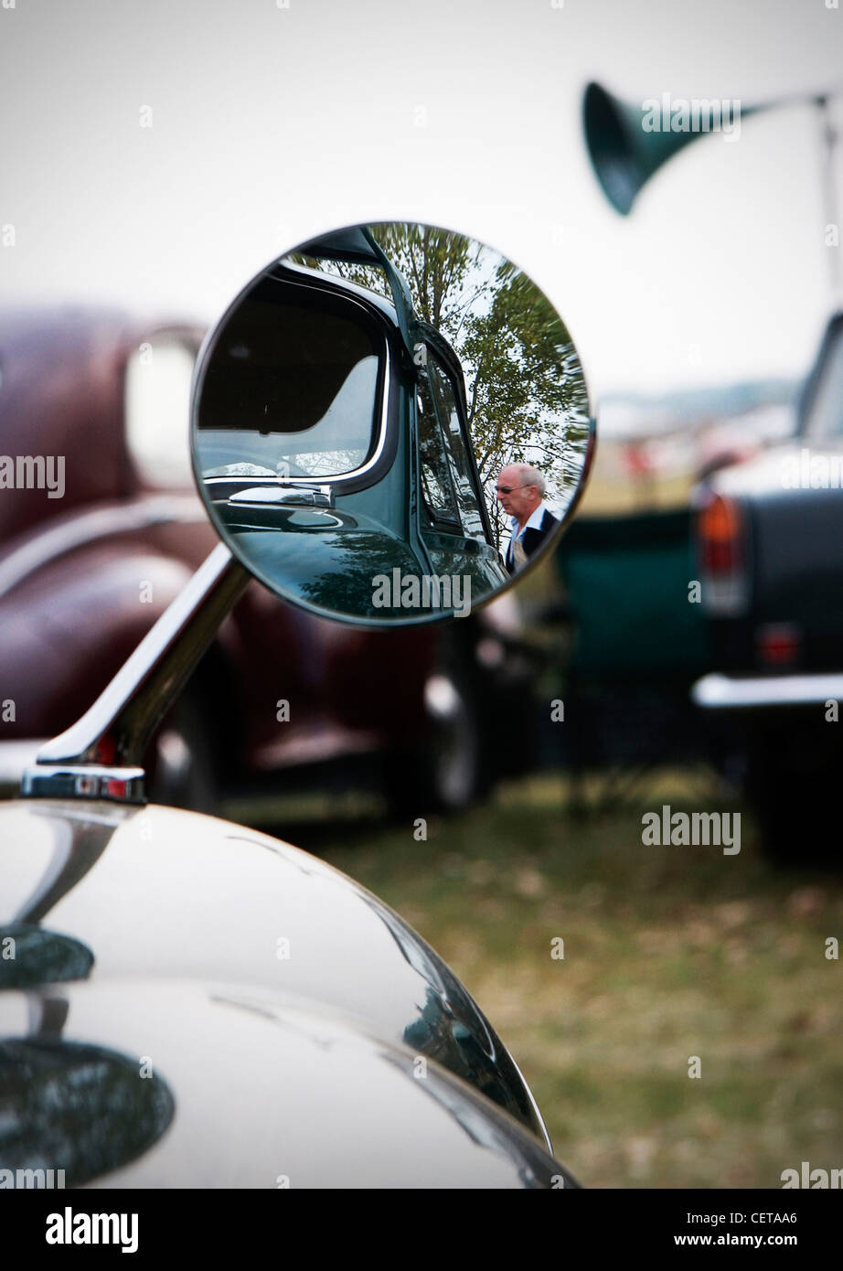 Reflection of man walking through side view mirror at Goodwood Revival. Stock Photo