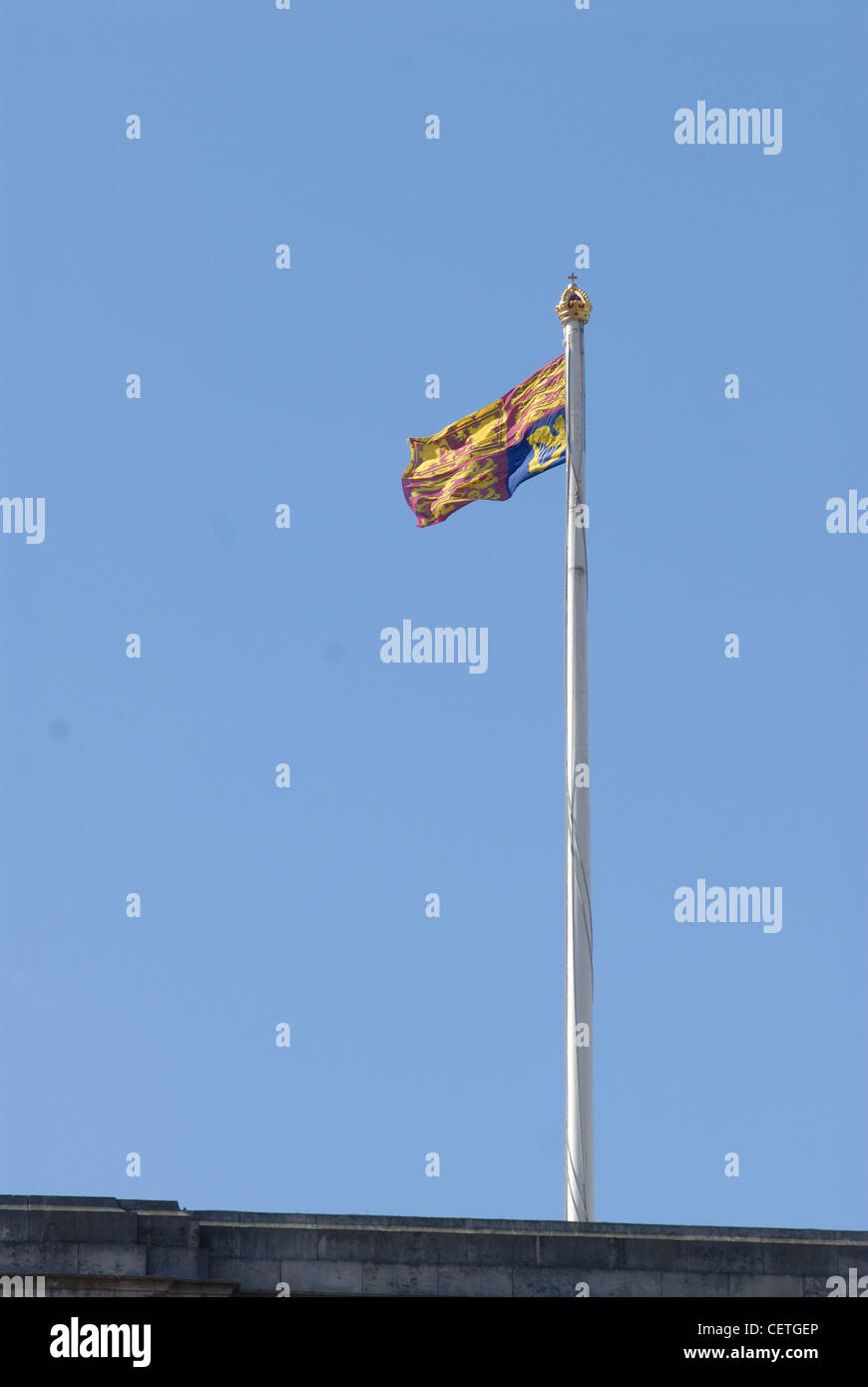 The Royal Standard atop Buckingham Palace. Buckingham Palace serves as both the office and London residence of Her Majesty The Q Stock Photo
