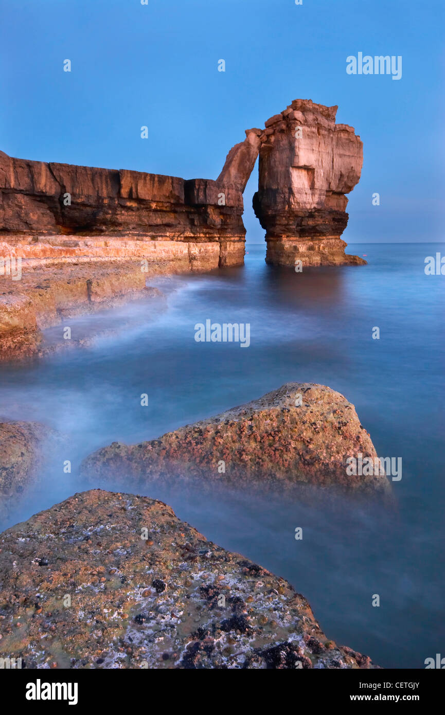 Pulpit Rock at the western edge of Portland Bill. A curious stone pillar showing the original ground level before quarrying. Stock Photo