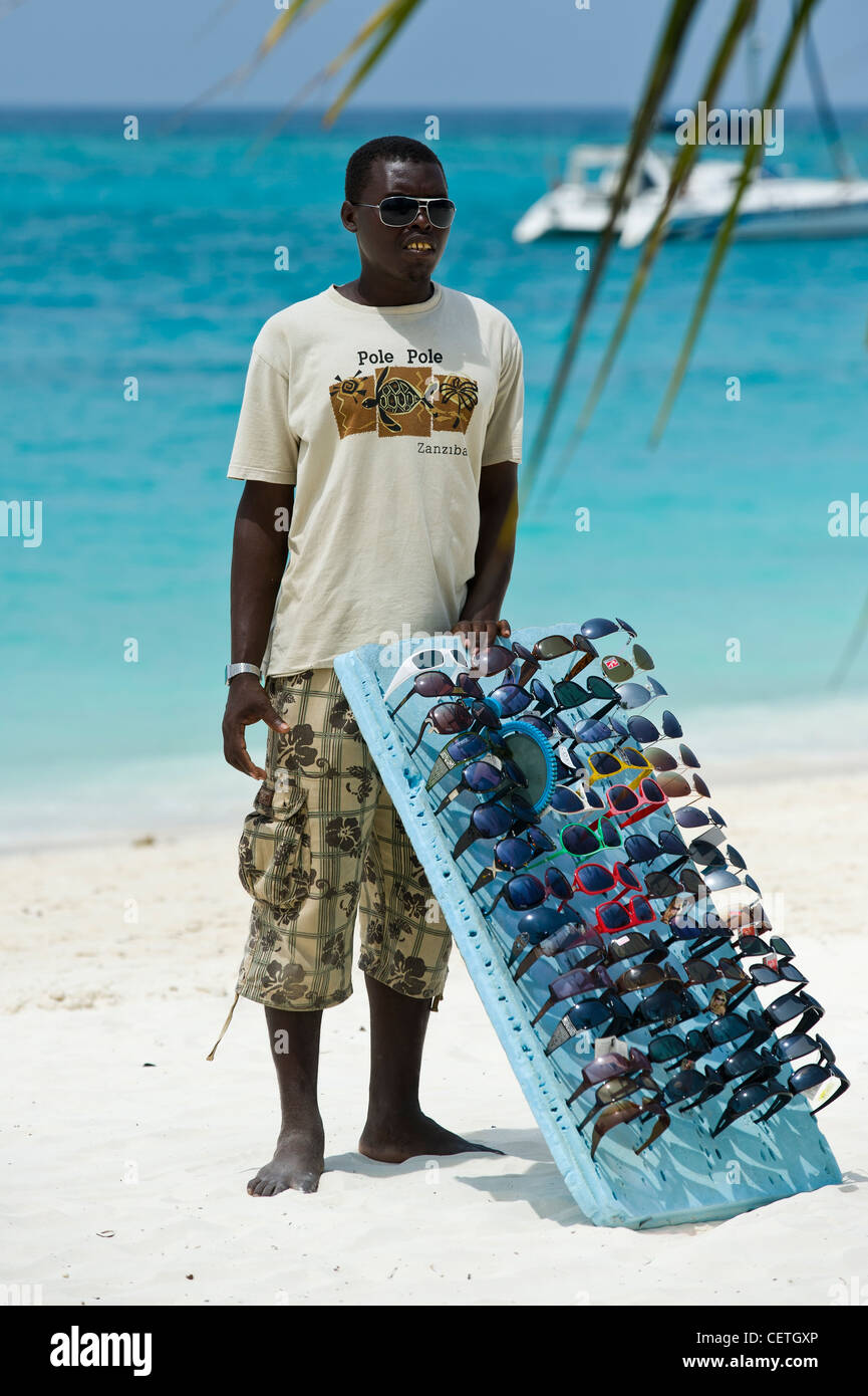 Salesman selling sunglasses on the beach of Kendwa Rocks north coast of Zanzibar Stock Photo