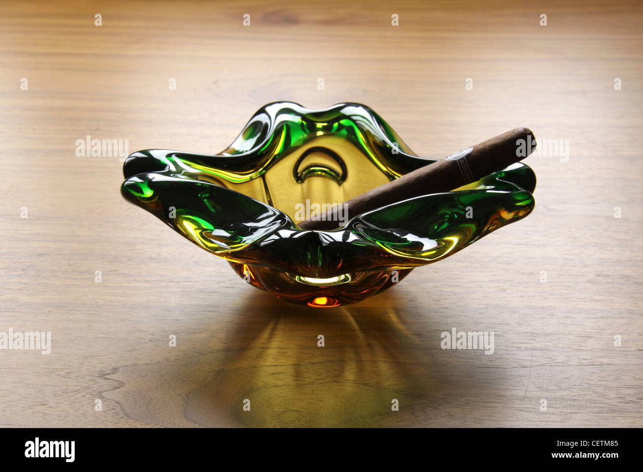 Green yellow glass ash tray with cuban cigar. Kitsch art deco design vintage antique Stock Photo