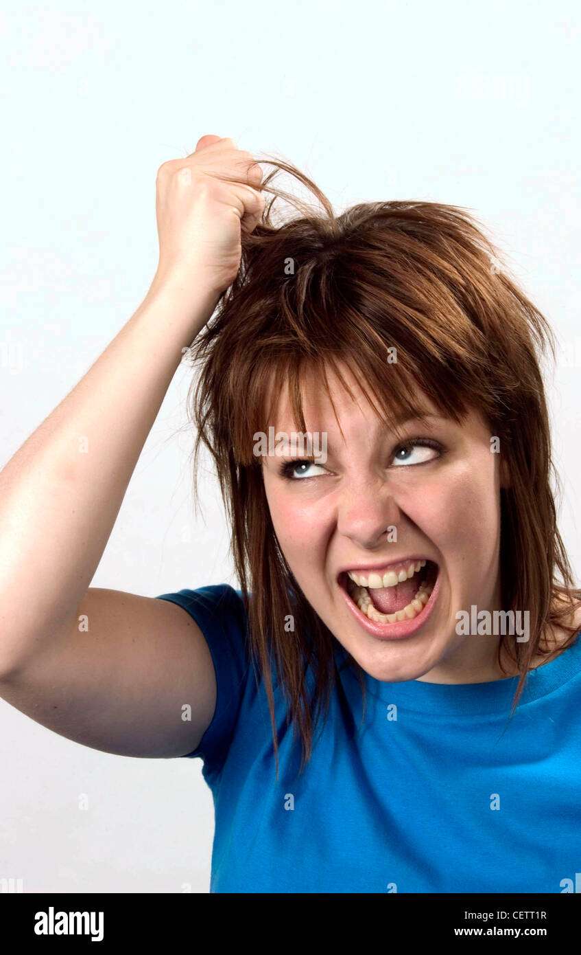 Female with shoulder length hair wearing blue t shirt pulling