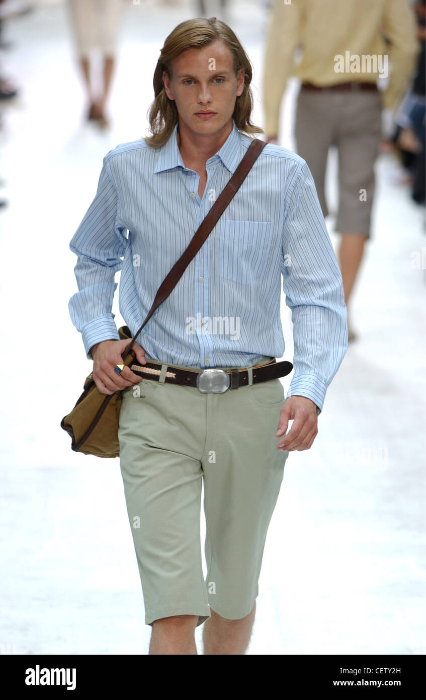 Paul Smith Paris Menswear S S Male model wearing striped blue shirt and  grey Bermuda shorts, carrying brown shoulder bag Stock Photo - Alamy