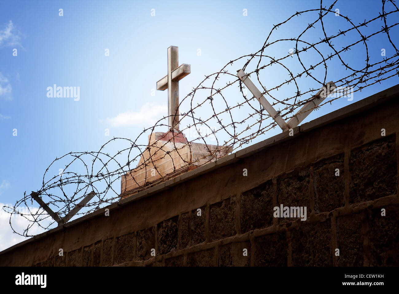 War and religion concept - Cross and barbed wire over blue sky Stock Photo