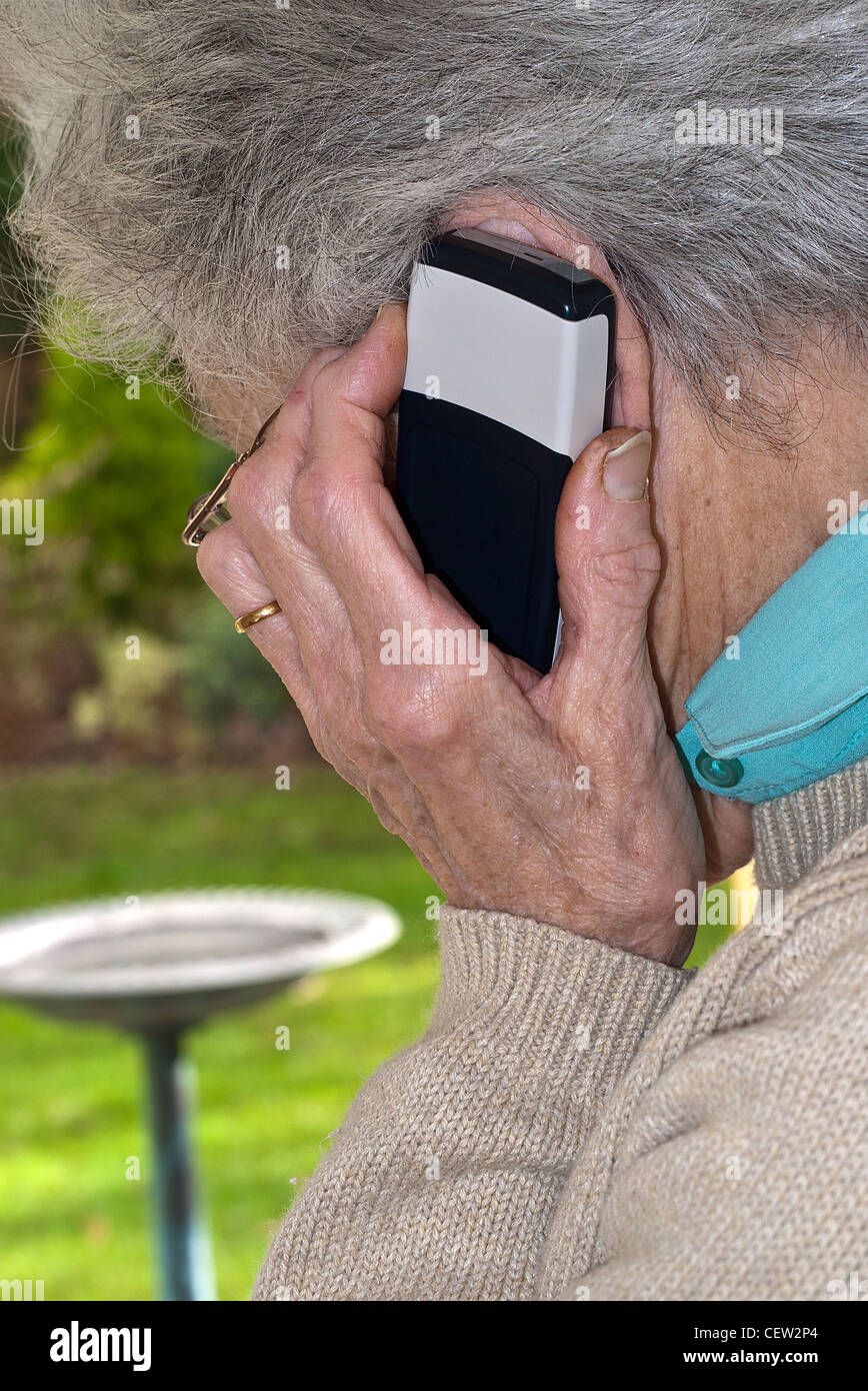 Mature Lady holding mobile phone to ear making a phone call Stock Photo