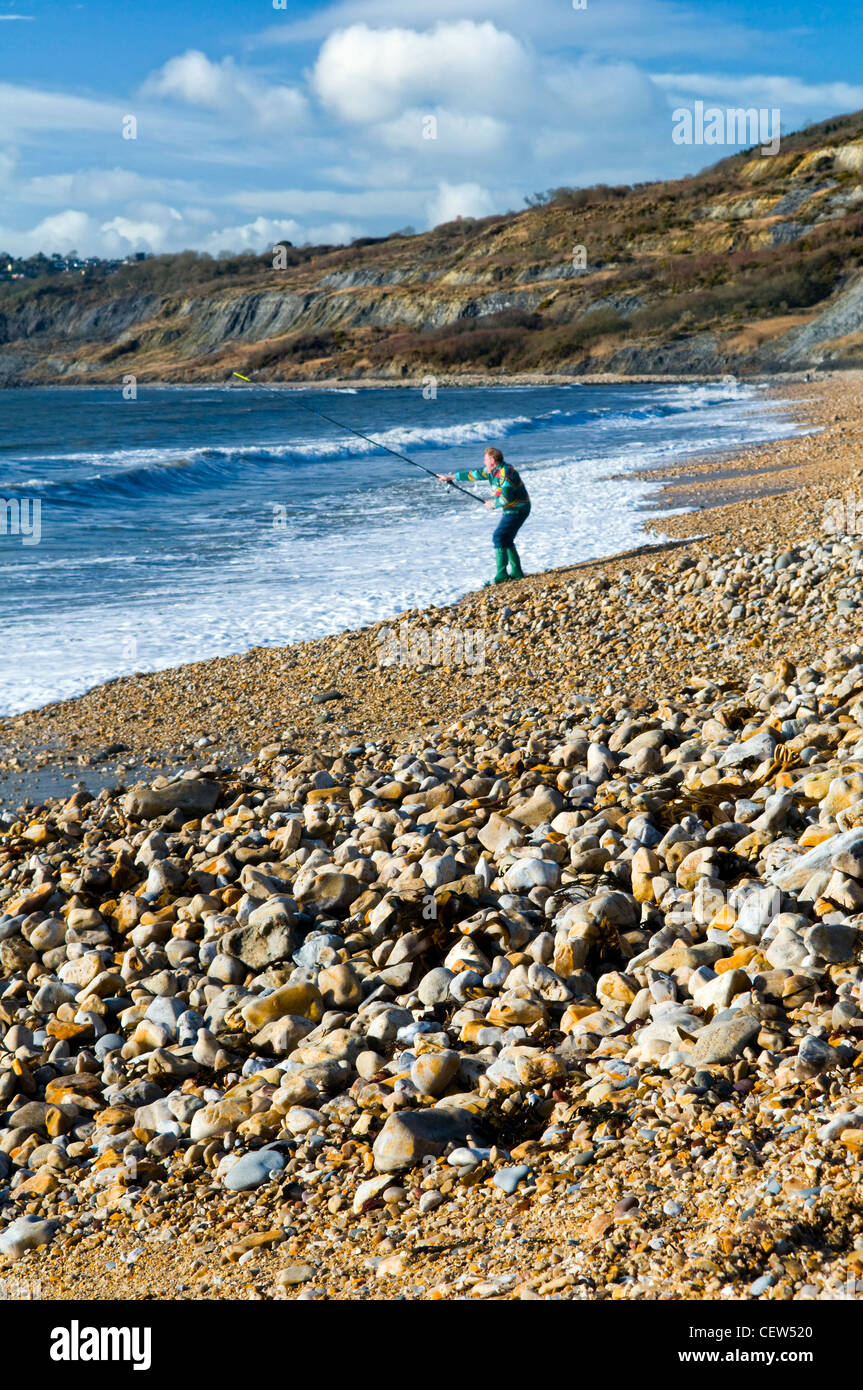 Charmouth beach on the jurassic coast at Charmouth, Dorset, UK taken on sunny day in winter with fisherman on beach Stock Photo