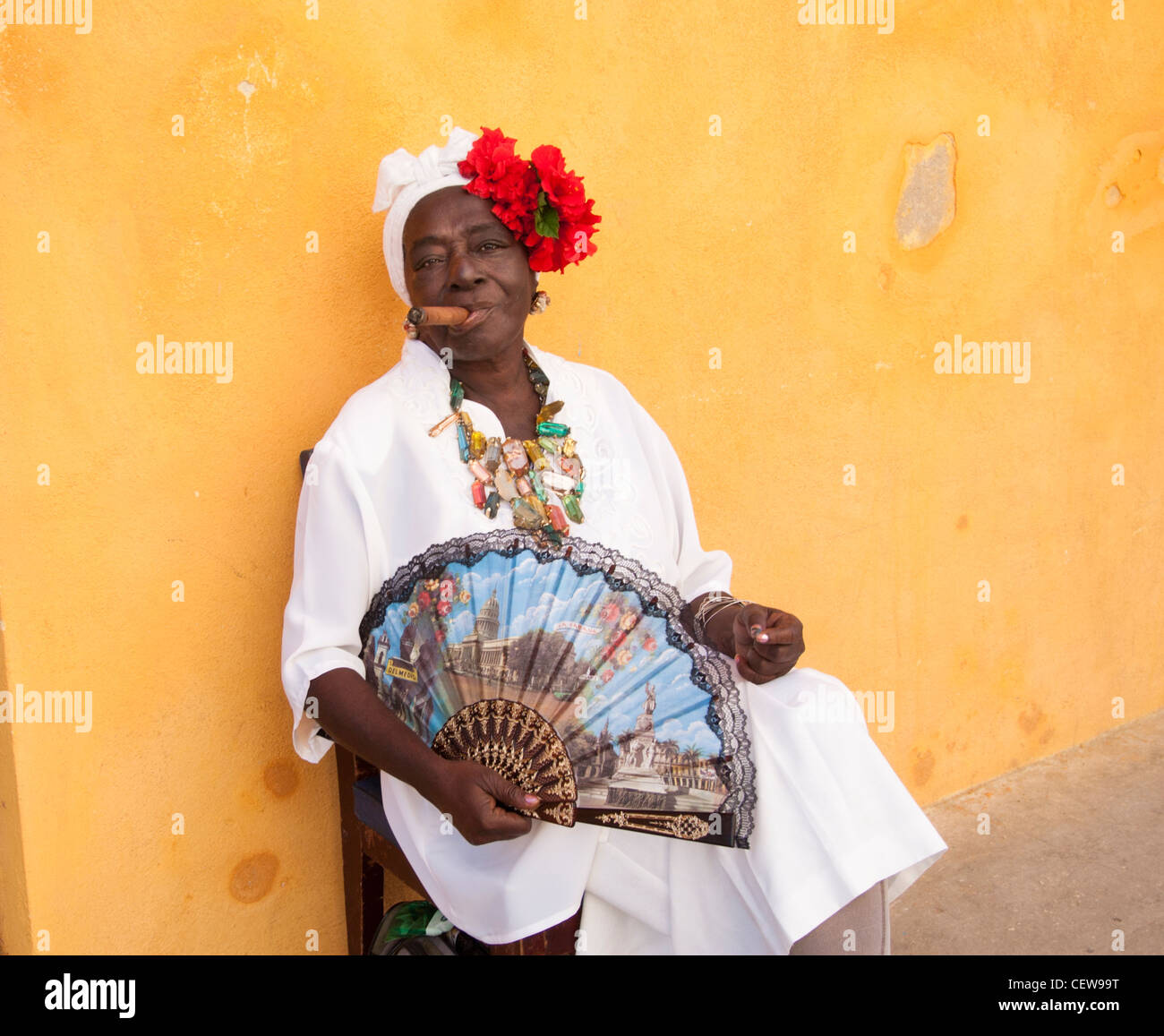 Cuban woman wearing a Santeria white dress smoking a big cigar, Havana, Cuba Stock Photo