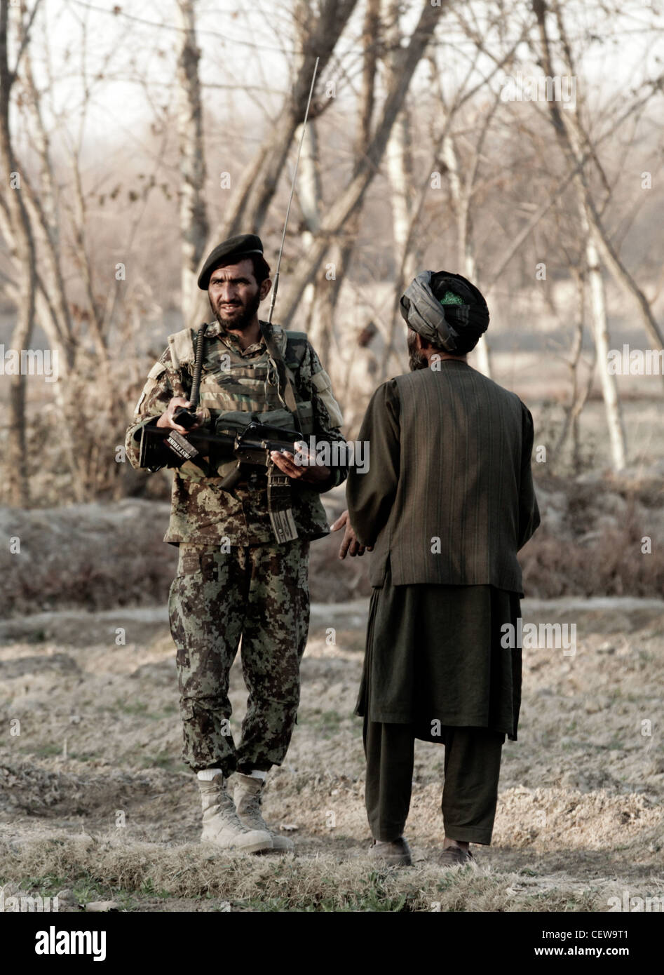 SANGIN DISTRICT, Helmand Province, Afghanistan- Afghan National Army Lance Cpl. Din Mohammed, a radio operator with 3rd Tolai, 2nd Kandak, 2nd Brigade, 215th Corps, speaks with a local villager during a security patrol here, Feb. 9. U.S. Marines recently transferred authority of the local patrol base, Hanjar Yak, to the ANA. Afghan soldiers provide security for the local area by conducting patrols and maintaining positive relations with local villagers. Stock Photo