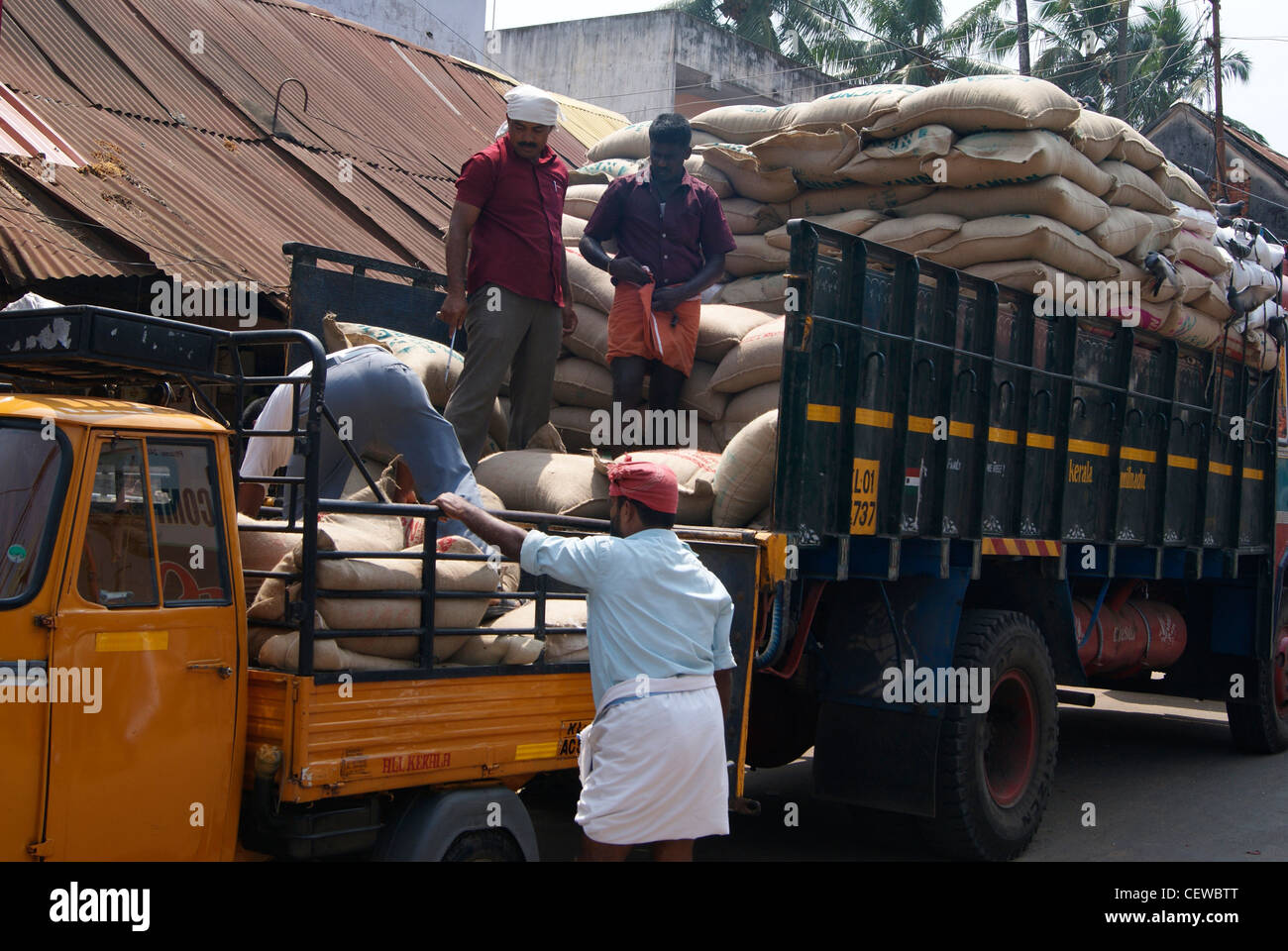 Transferring Bulk Quantity of Rice sacks from Big Lorry to a Mini Pick Up van.Scene from Chalai market at Trivandrum city(India) Stock Photo