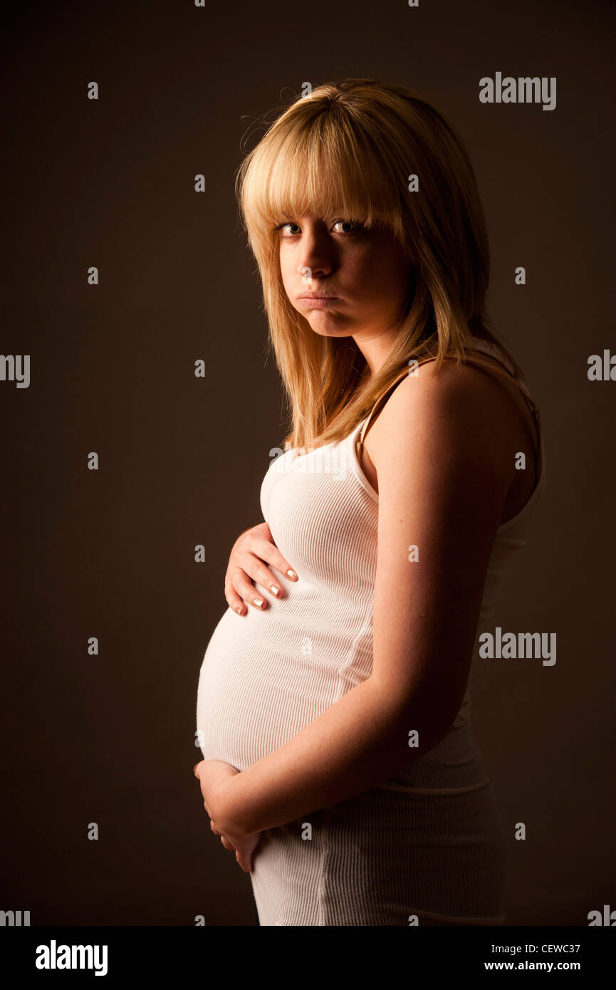 pregnant yong teen a pregnant young teenage blonde haired girl woman - unwanted pregnancy  contraception family planning uk Stock Photo - Alamy