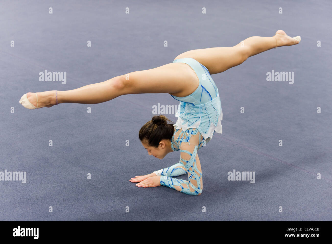 Female gymnast performing elbow stand Stock Photo