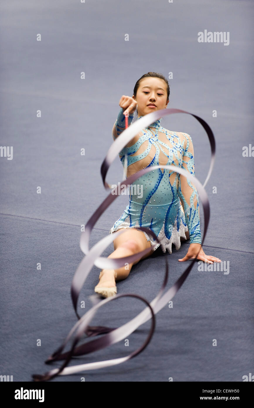 Female gymnast performing floor routine with ribbon Stock Photo