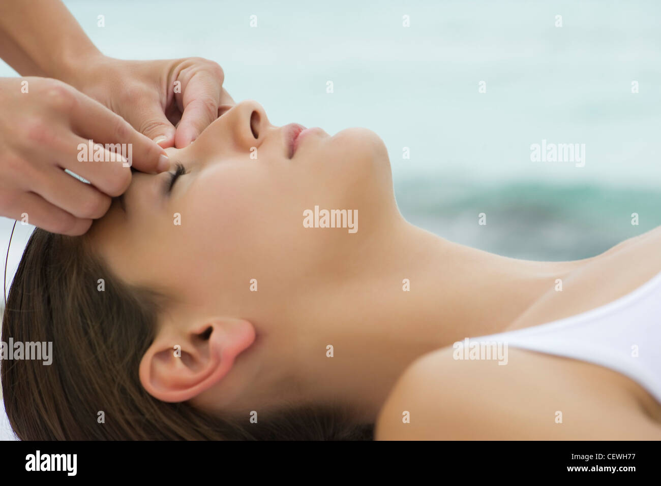 Young woman receiving face massage, side view Stock Photo