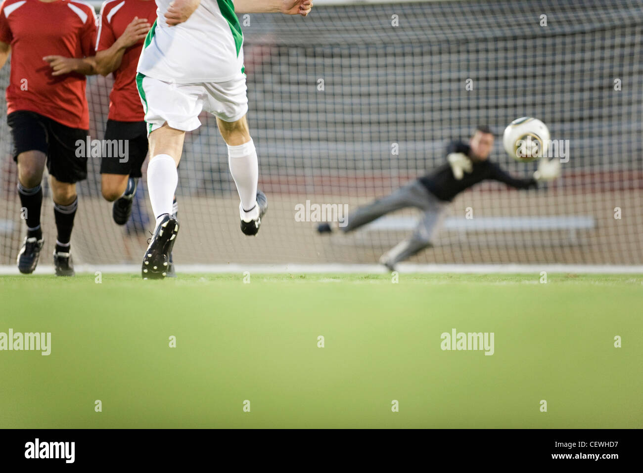 Soccer player shooting ball at goal, cropped Stock Photo