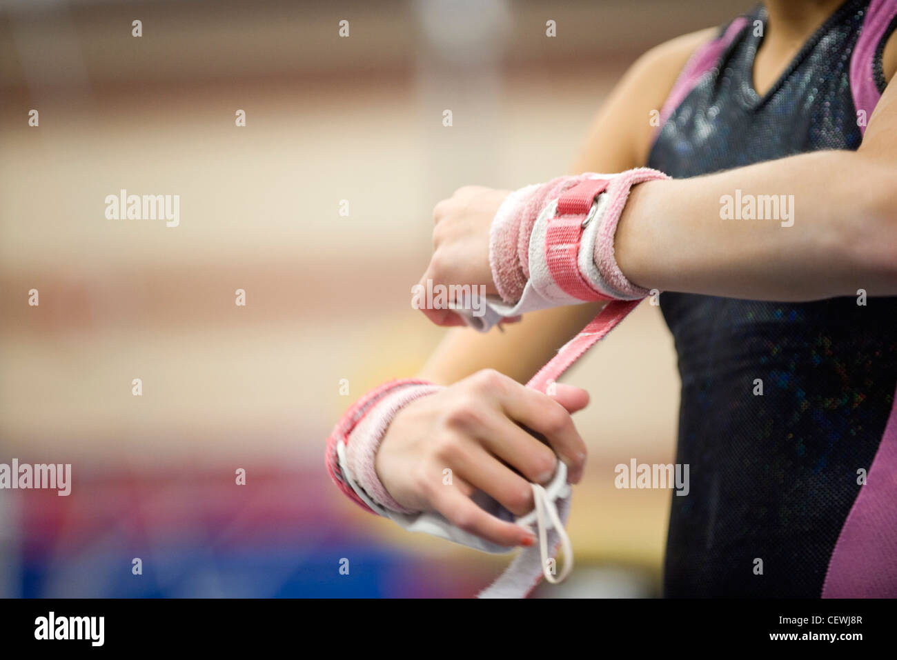 Female gymnast wrapping wrists in preparation, cropped Stock Photo Alamy