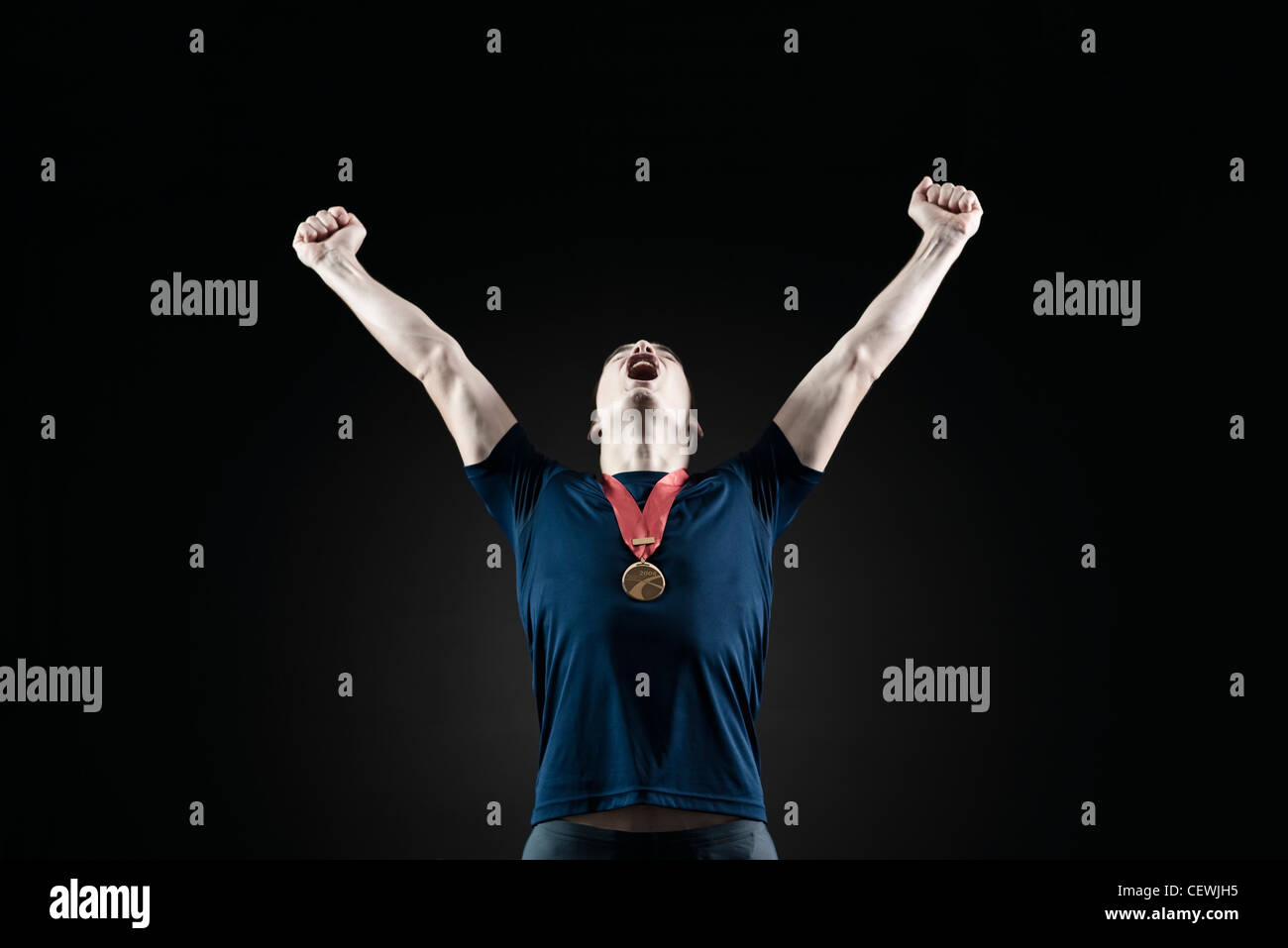 Male athlete shouting with arms raised in victory Stock Photo Alamy