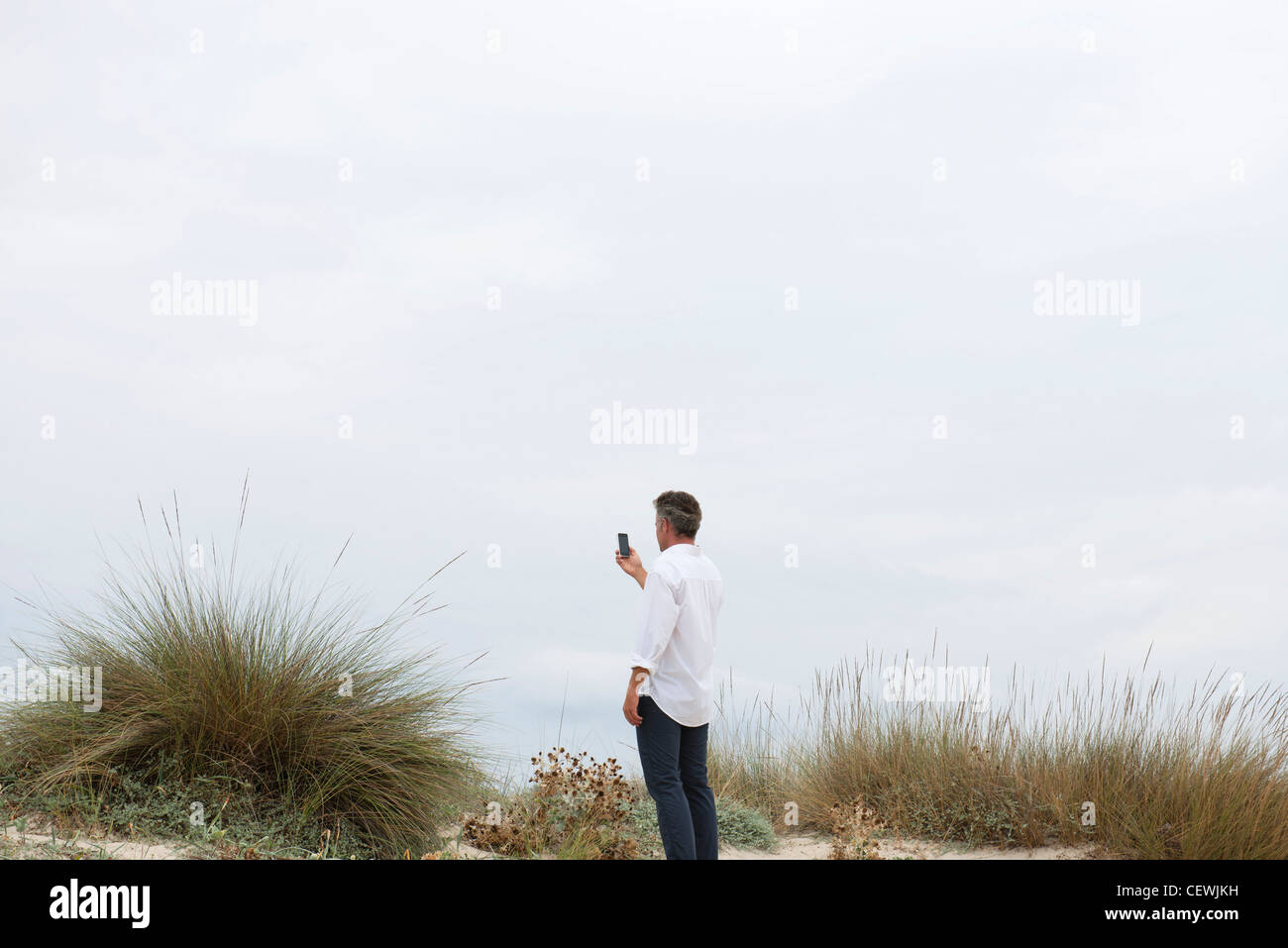 Man holding cell phone outdoors Stock Photo