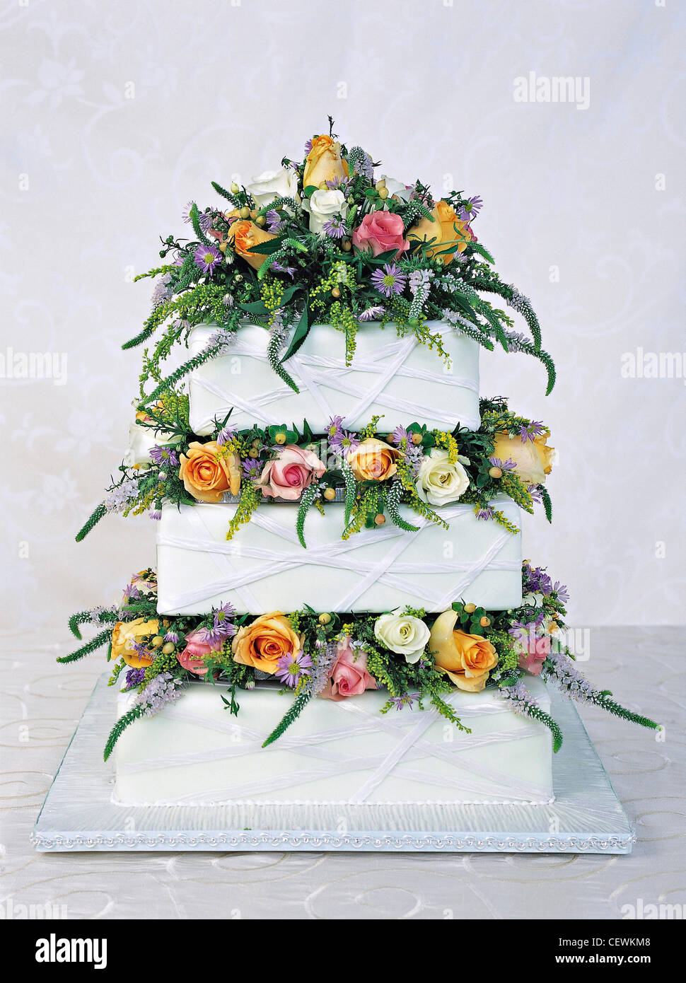 Sugar paste cake with white icing and layered with fresh flowers NOTrue