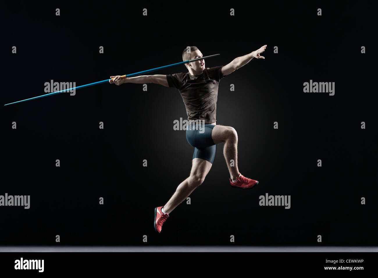 Male athlete leaping with javelin Stock Photo