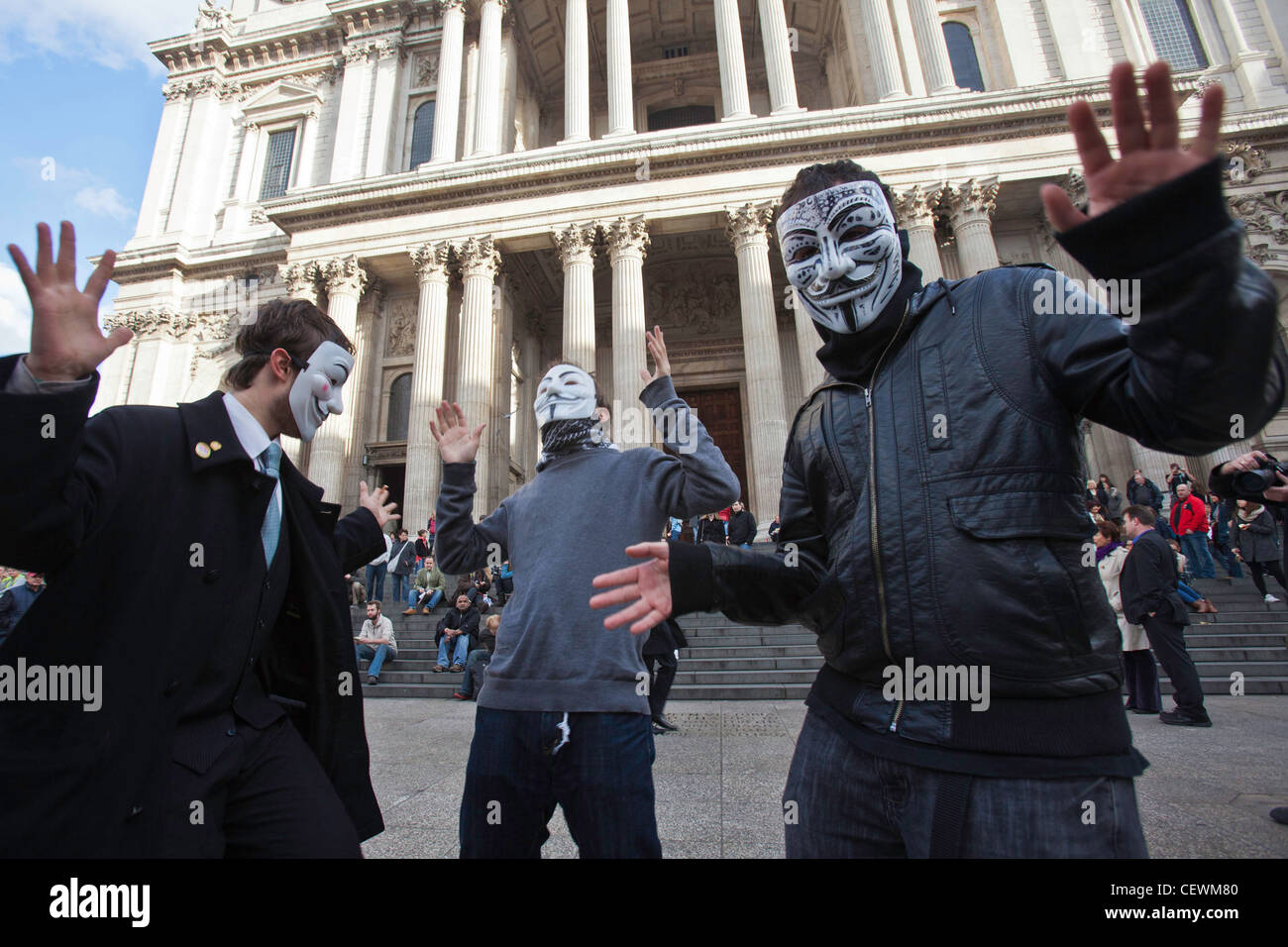 Masked demonstrators from Anonymous UK at Occupy London OSLX protest, dance in front of St Paul's Cathedral, London. Stock Photo