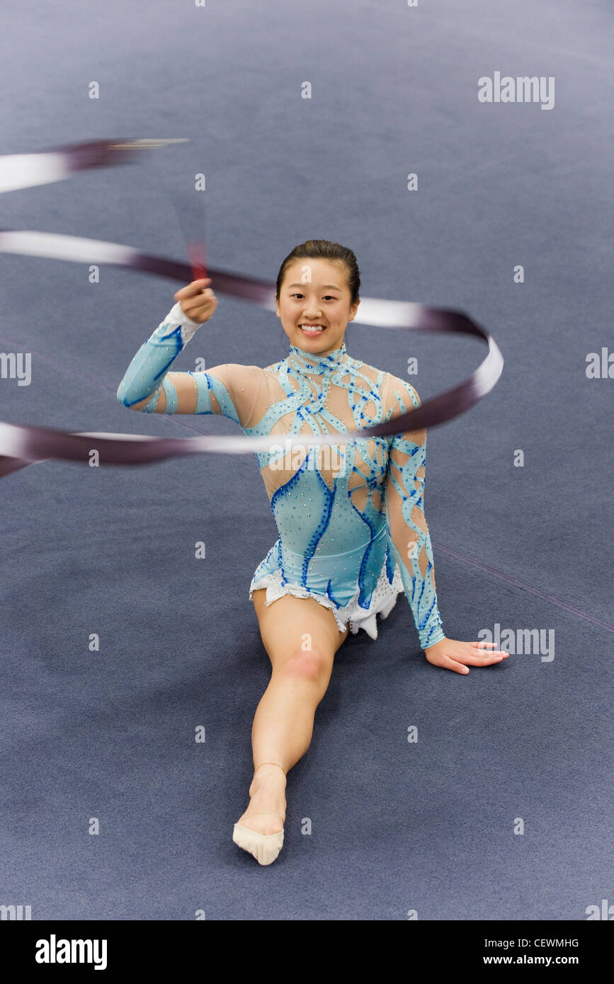 Female gymnast performing floor routine with ribbon Stock Photo