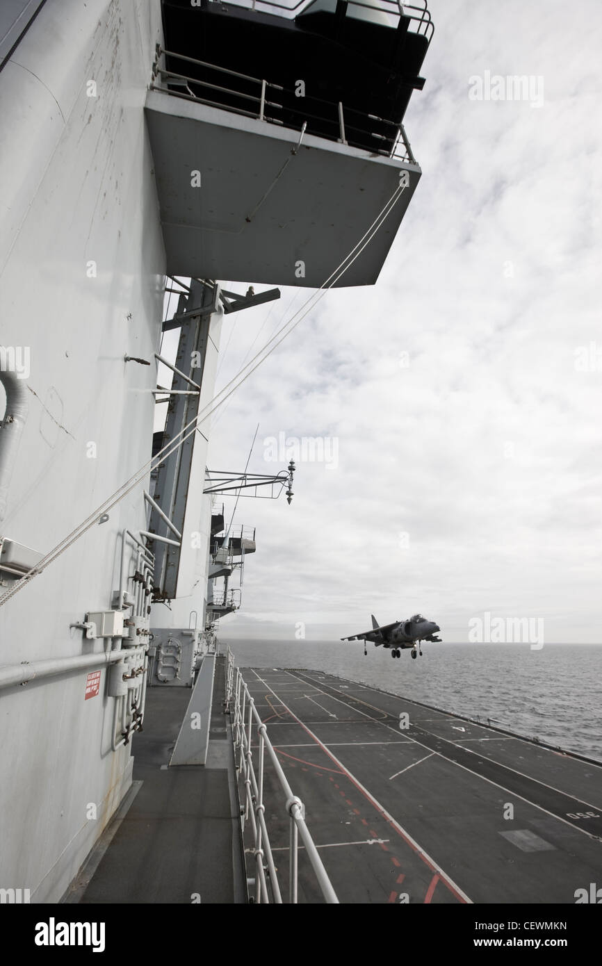 Harrier jet landing on naval aircraft carrier HMS Illustrius Stock Photo