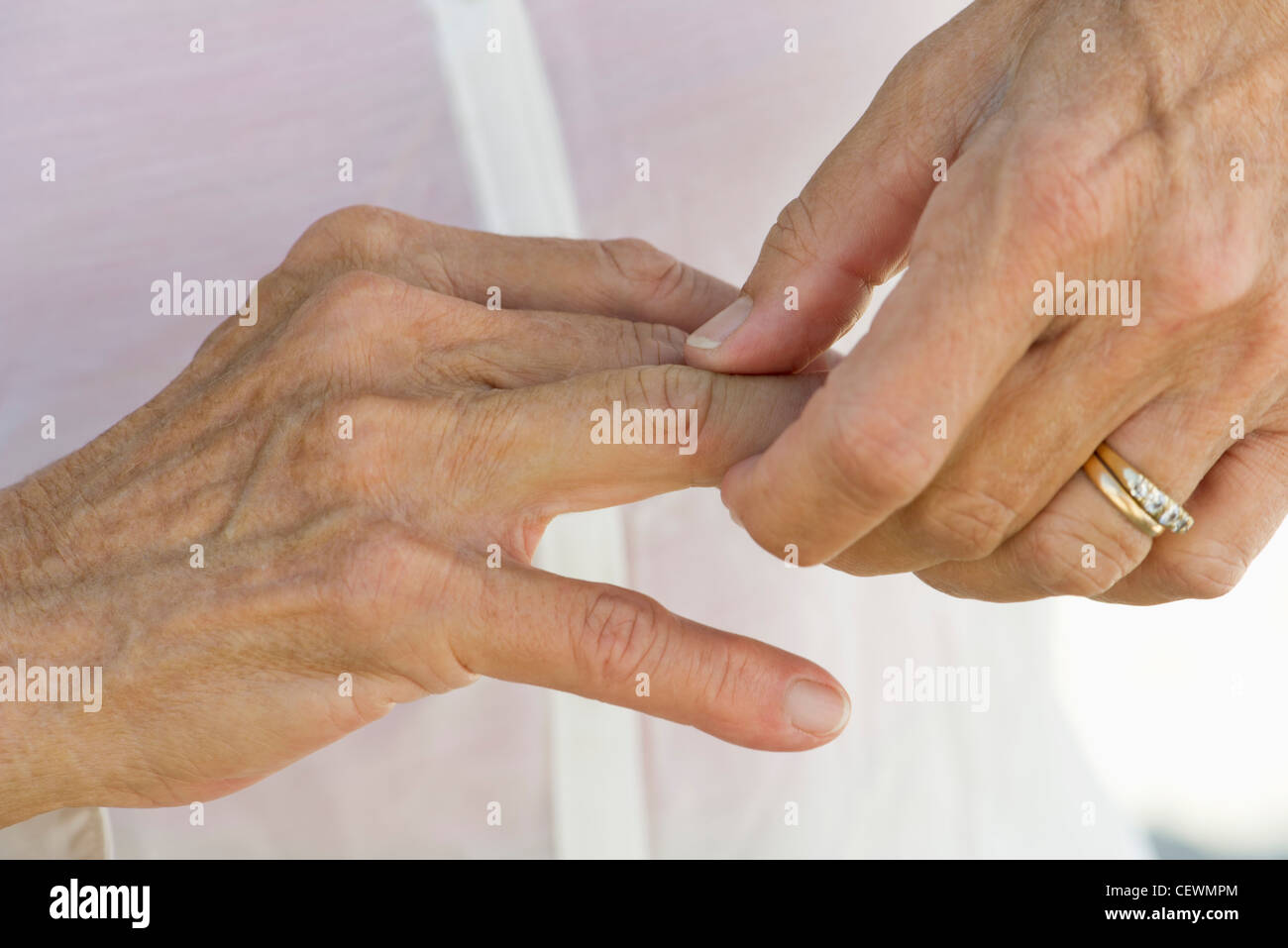 Senior woman rubbing knuckles, cropped Stock Photo