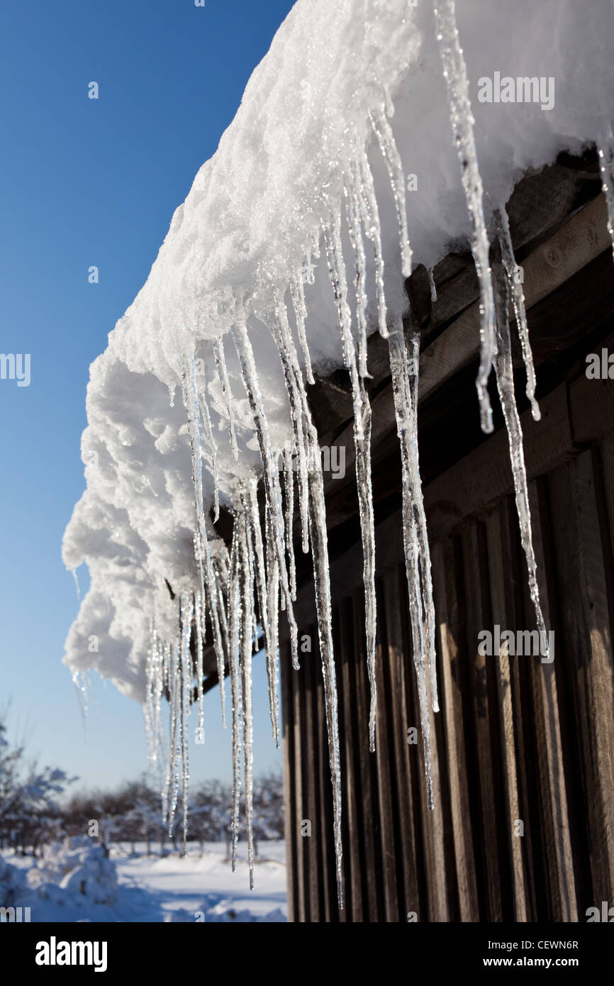 Closeup of icycles formed from snow on a roof Stock Photo - Alamy